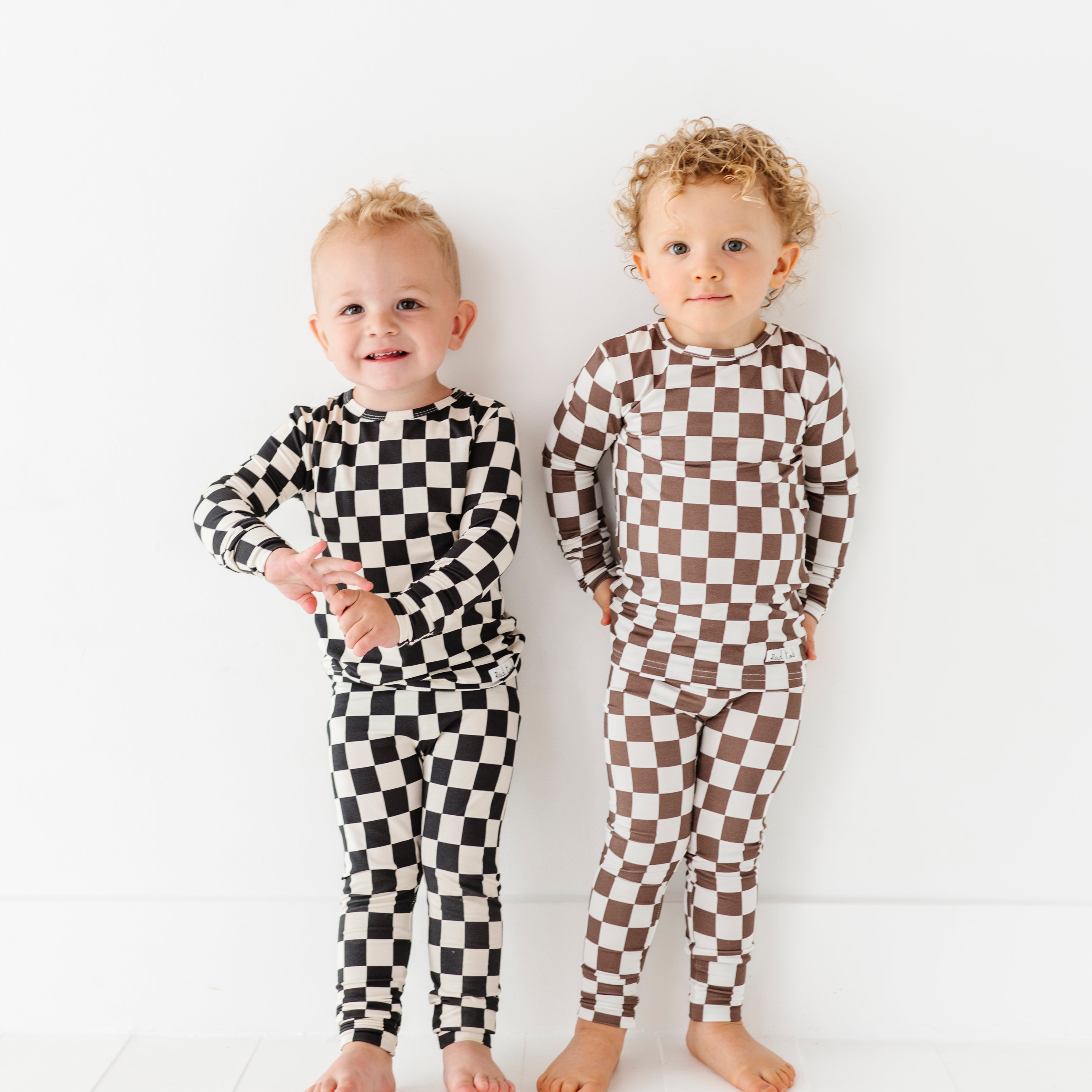 2 friends enjoying their Black checkered 2-piece pajamas for toddlers and kids, featuring a comfy fit and elastic waistband by Rad Toddler.