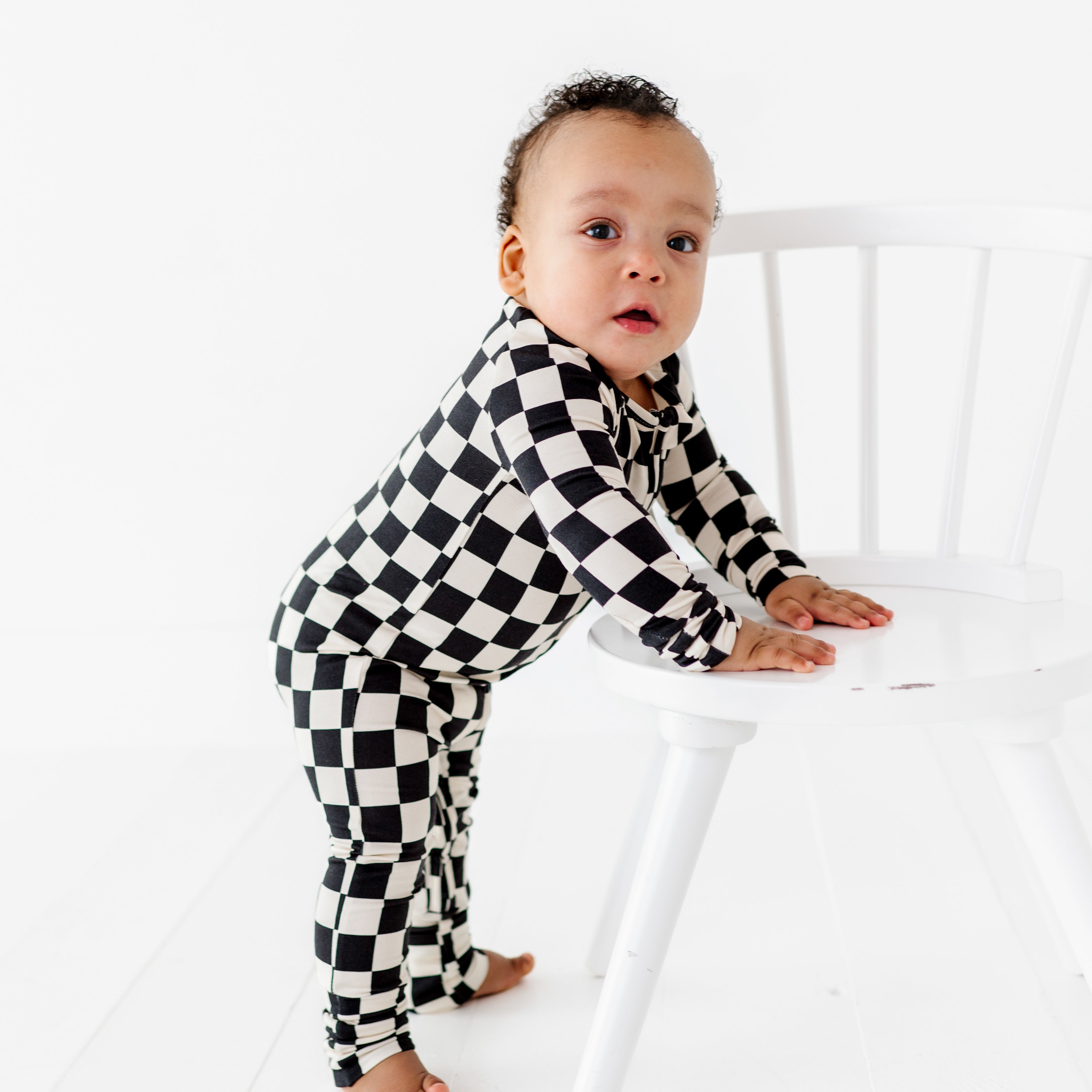 Toddler wearing black and white checkered bamboo onesie