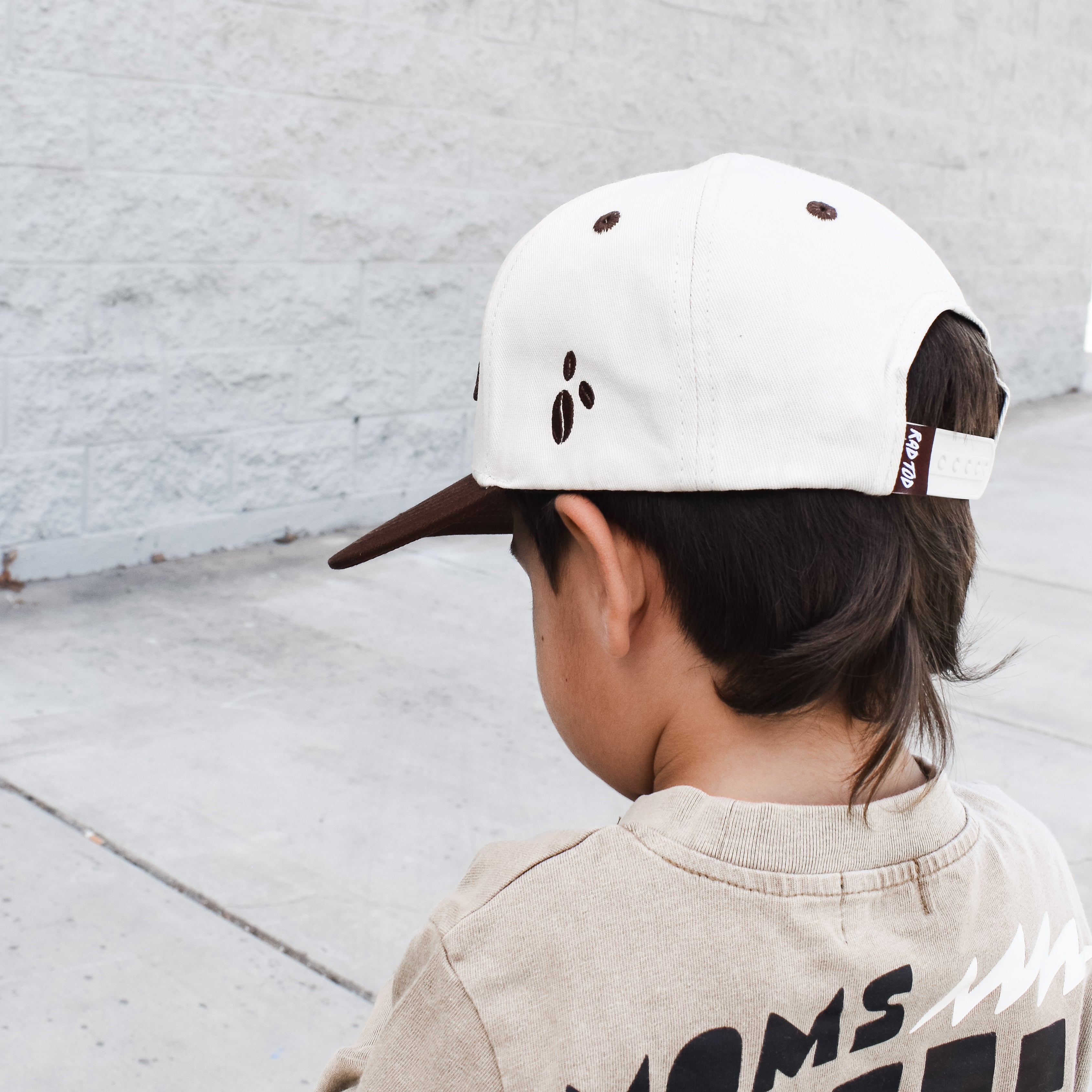 Side view of kids snapback highlighting the small coffee bean patch detail