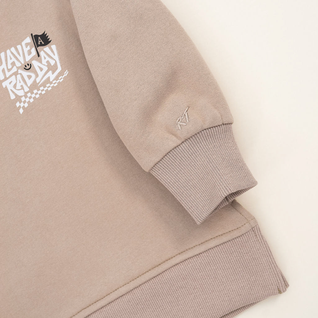 Kids beige graphic crewneck with playful white lettering and checkered design displayed on white background