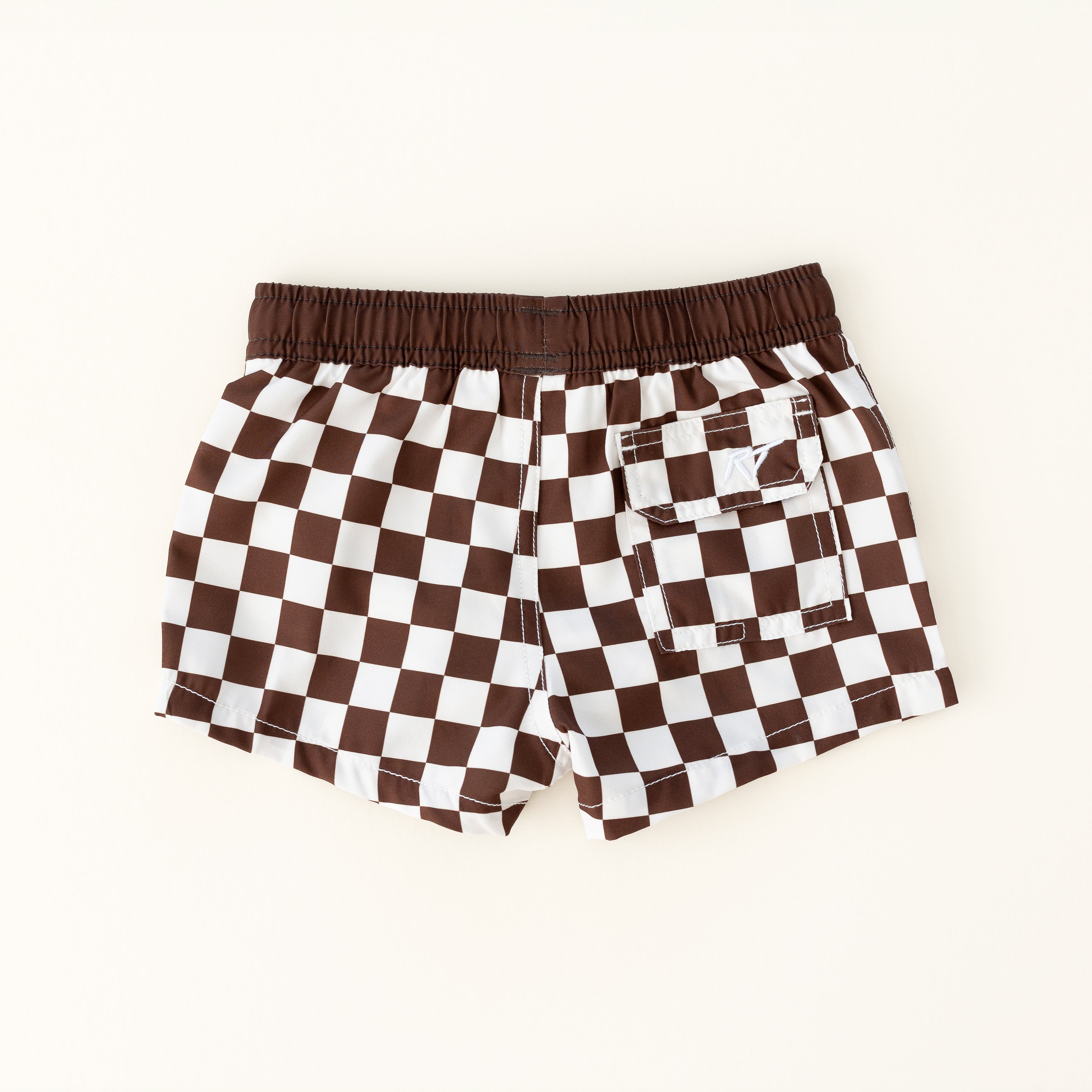 backside of Trendy checkered swim shorts with an elastic waistband and drawstring, made from quick-drying fabric. Ideal for swimming, beach trips, and outdoor activities. Features vibrant patterns and a comfortable fit for active kids.