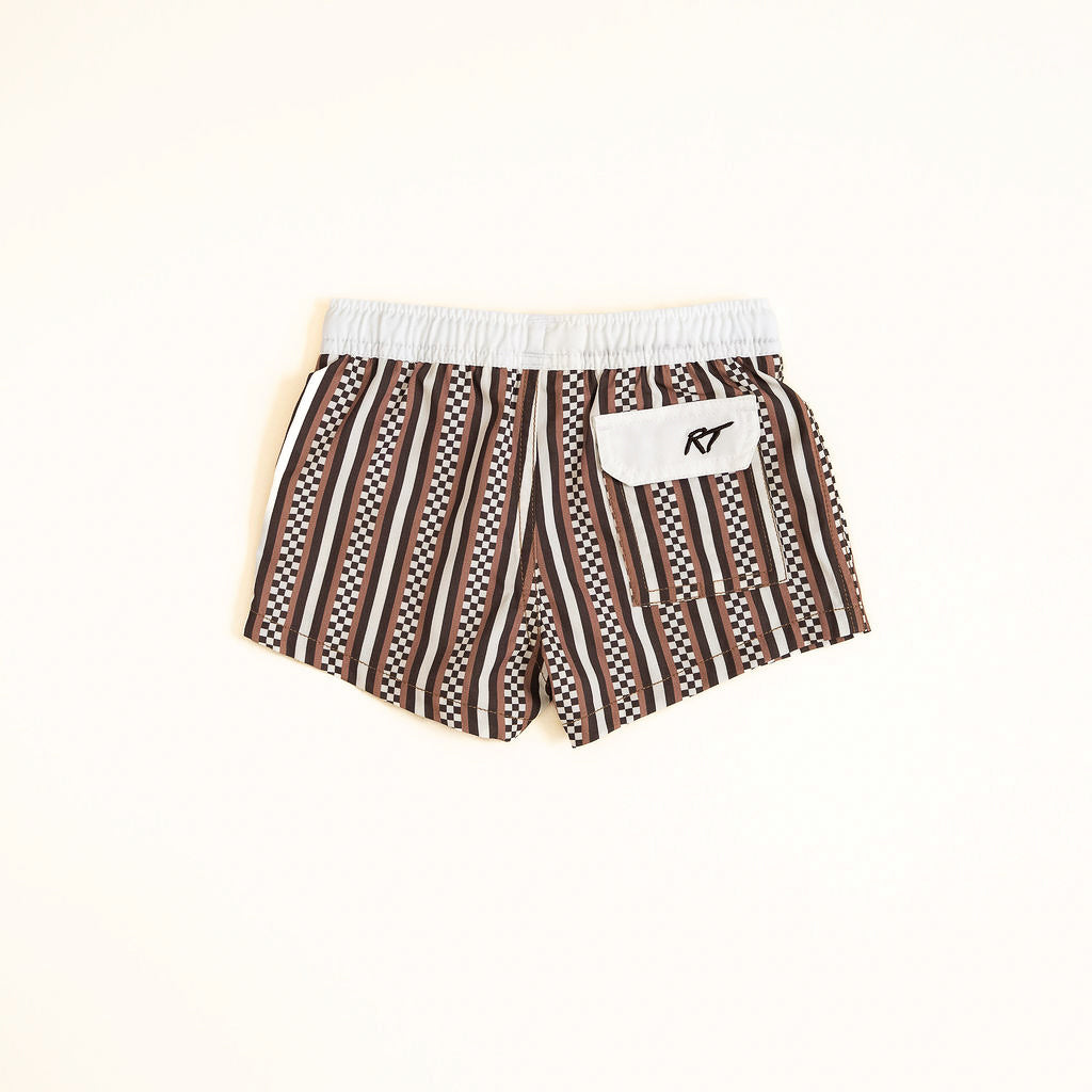 Brown and white patterned shorts with a logo on a beige background
