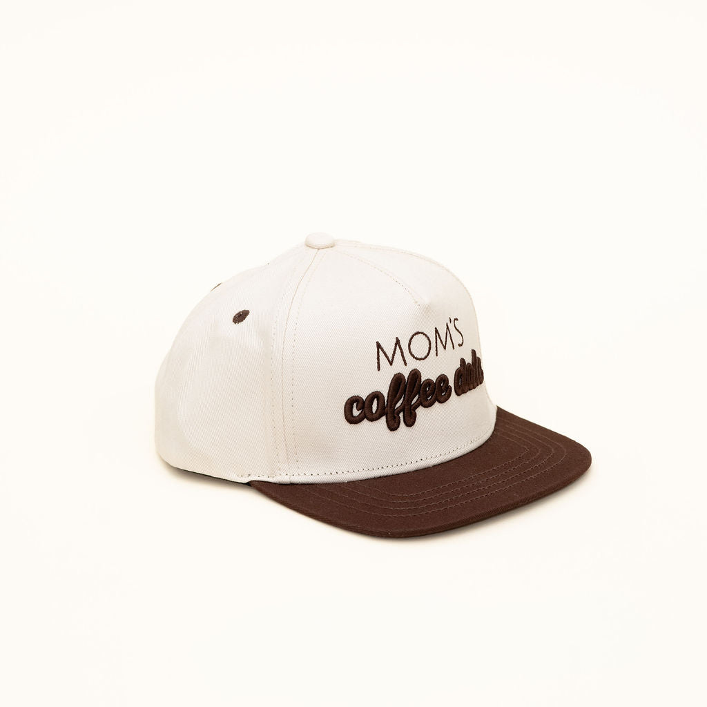 White cap with brown brim featuring 'MOMS coffee addict' text on a white background