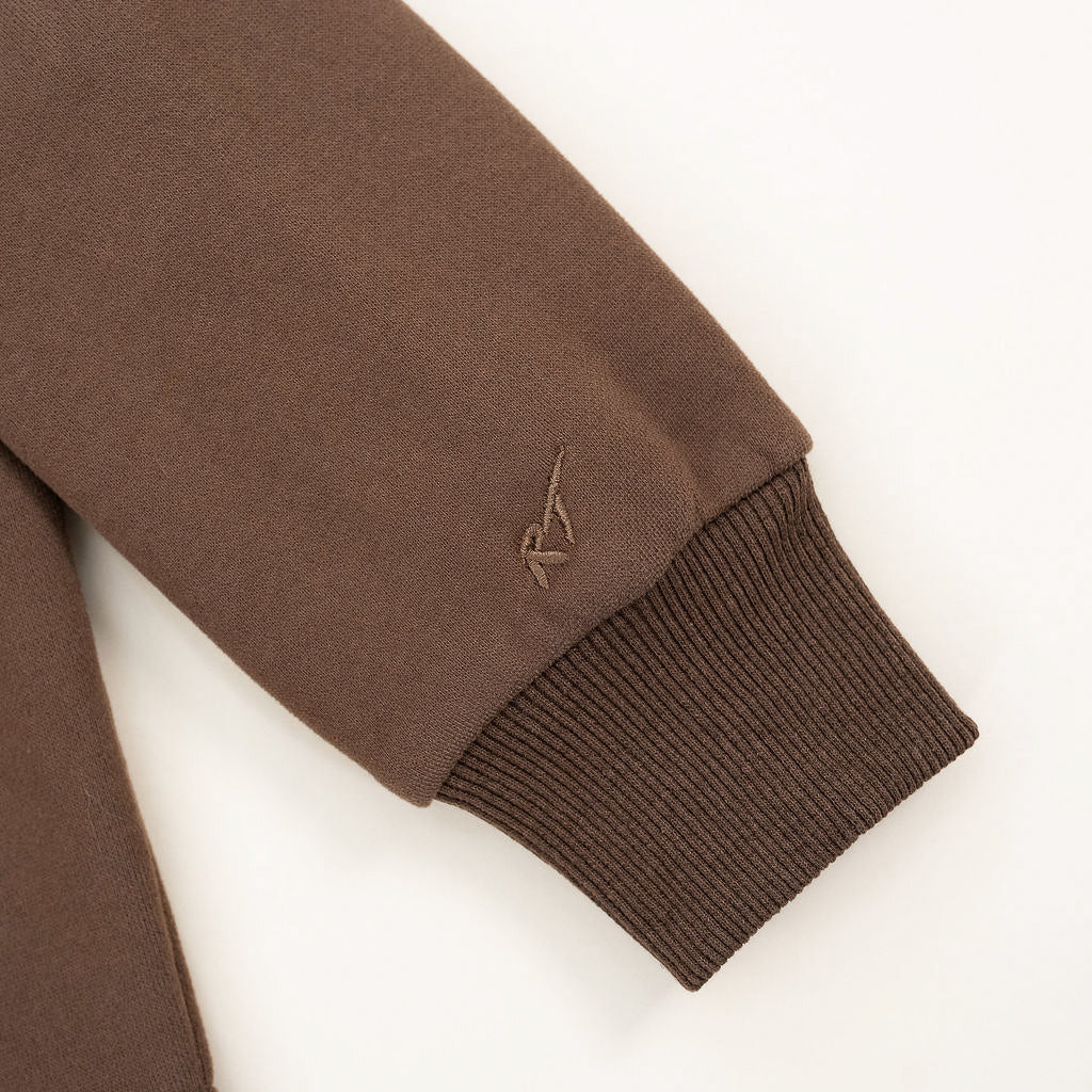 Brown jacket sleeve with a small logo on a white background