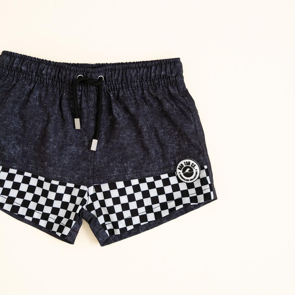 Black shorts with a checkered pattern on a white background by Rad Toddler