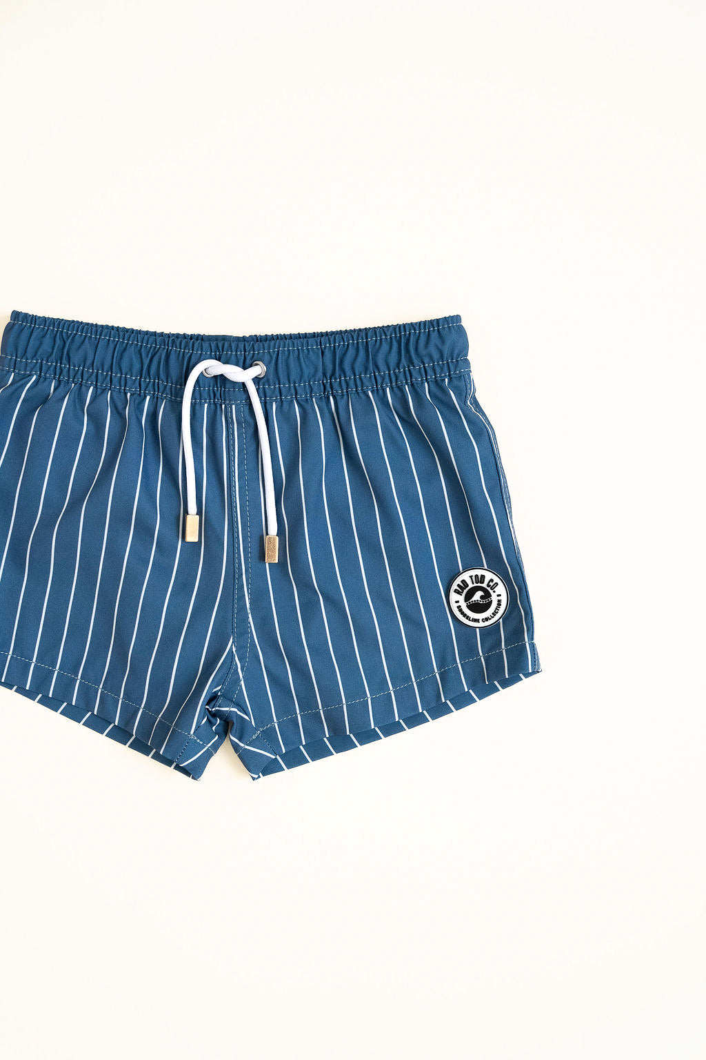 Blue striped shorts with a logo on a white background by rad toddler