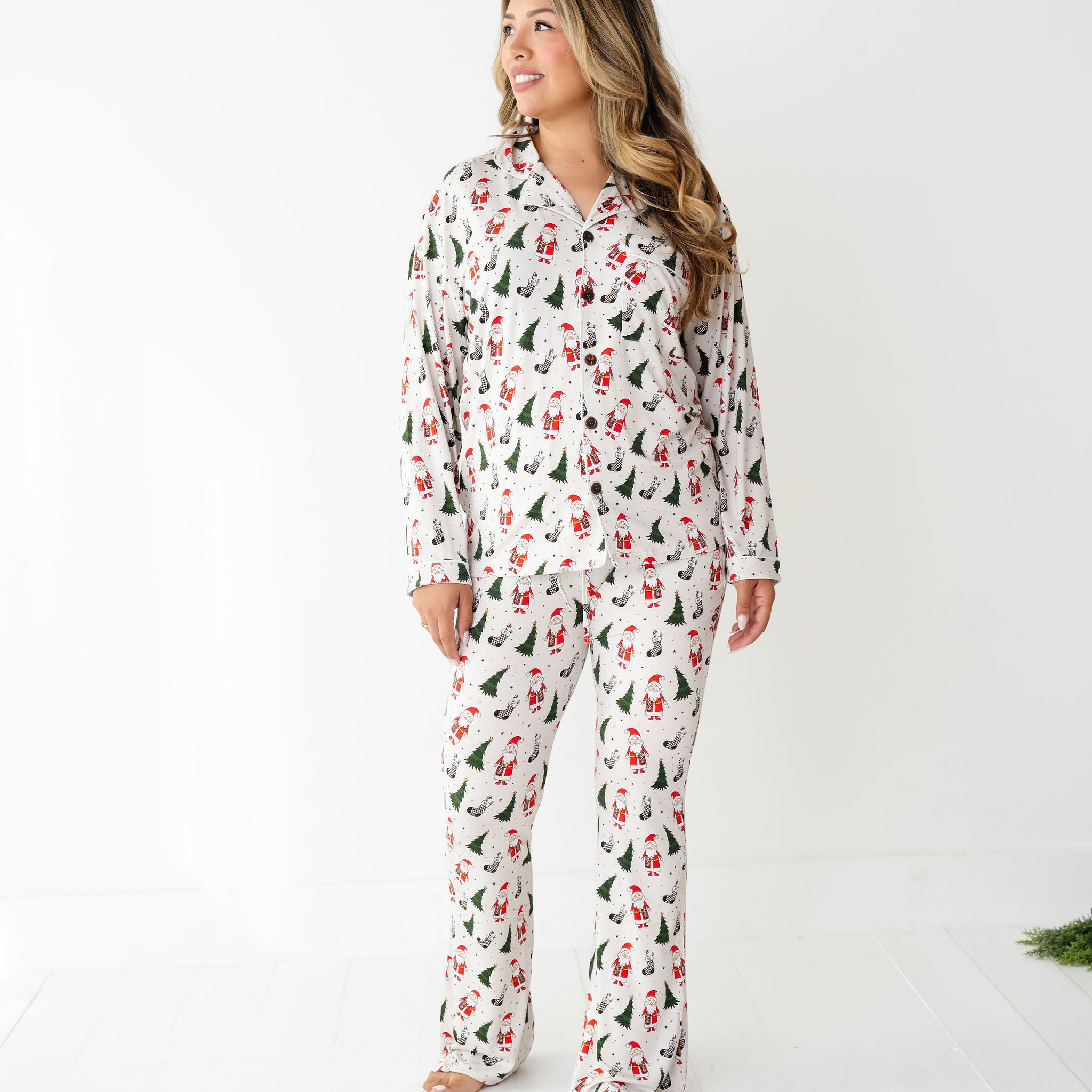 Woman wearing Merry Everything Bamboo Christmas Pajamas with Santa, trees, and checkered stockings by RAD Toddler