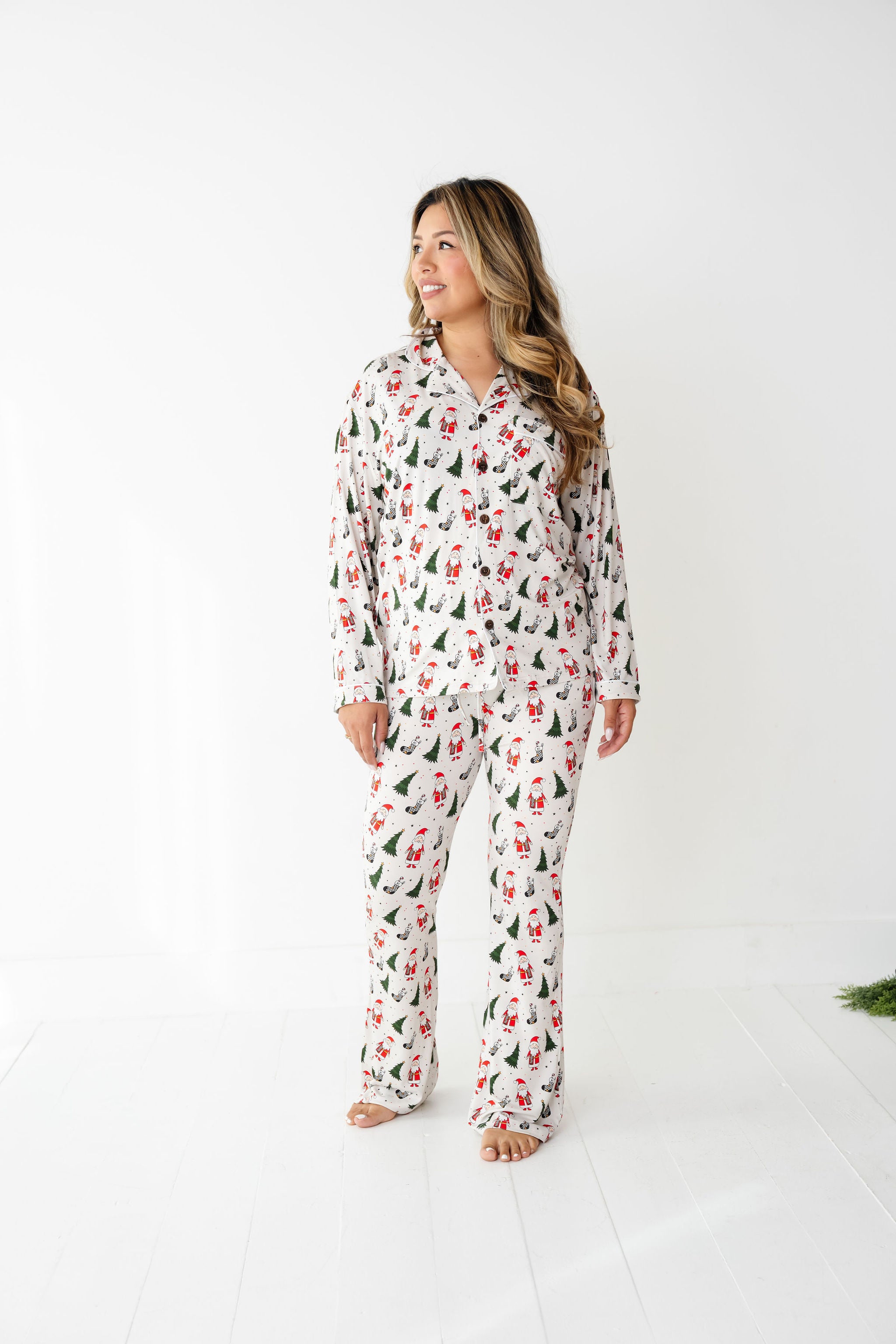 Woman wearing Merry Everything Bamboo Christmas Pajamas with Santa, trees, and checkered stockings by RAD Toddler