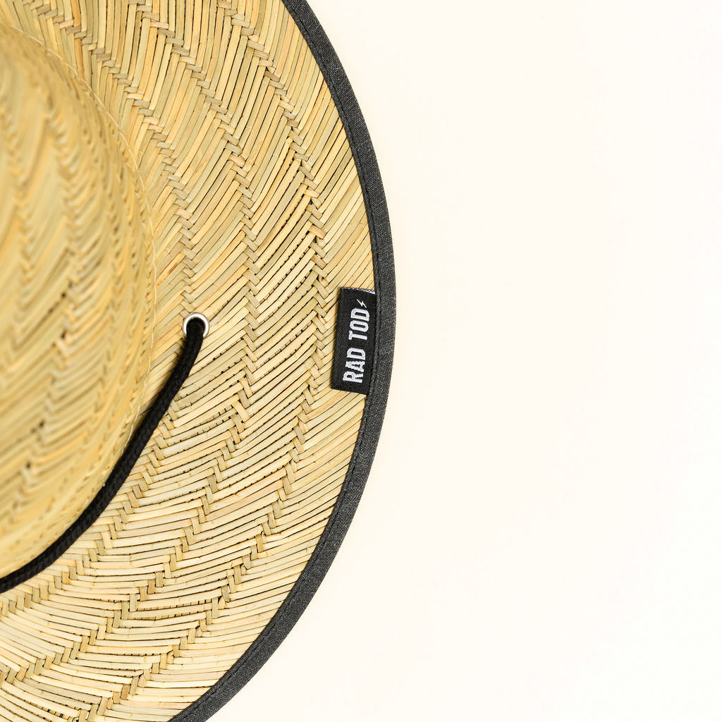 Acid Wash Black straw hat with classic straw exterior and black acid wash detail under the brim, wide brim providing sun protection for face, ears, and neck.