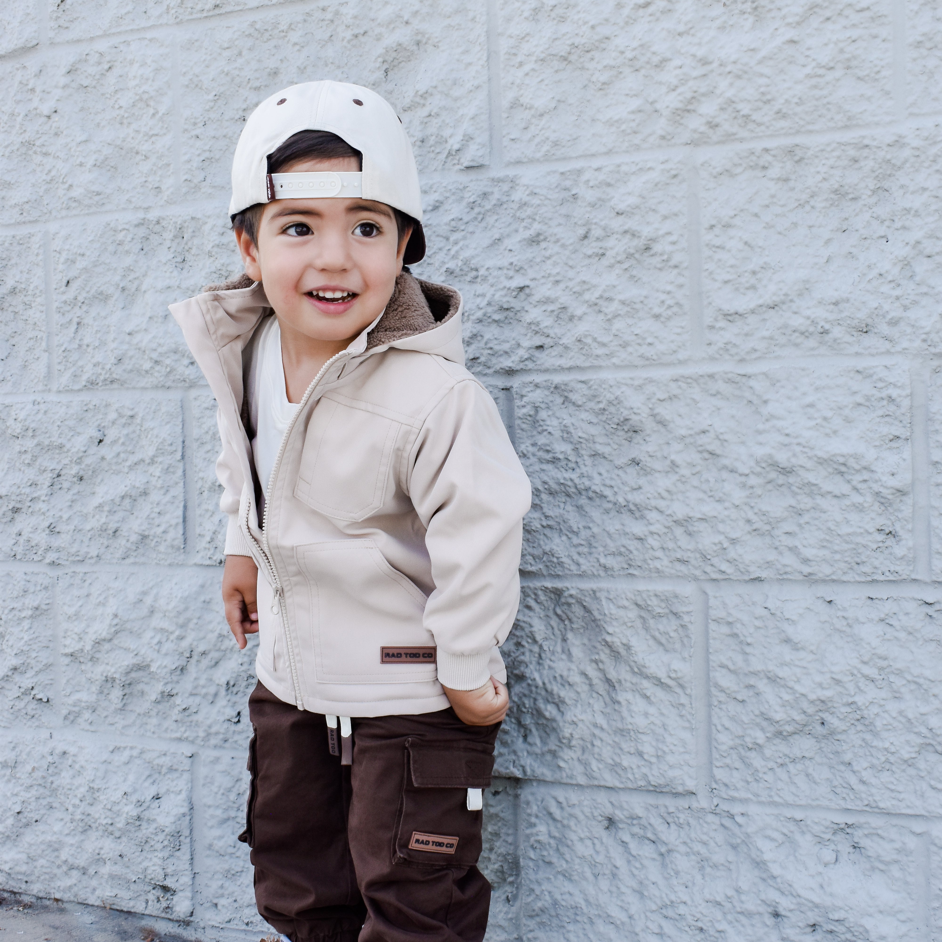 Banxs Jacket in Beige – premium sherpa-lined jacket with removable hood with smiling boy
