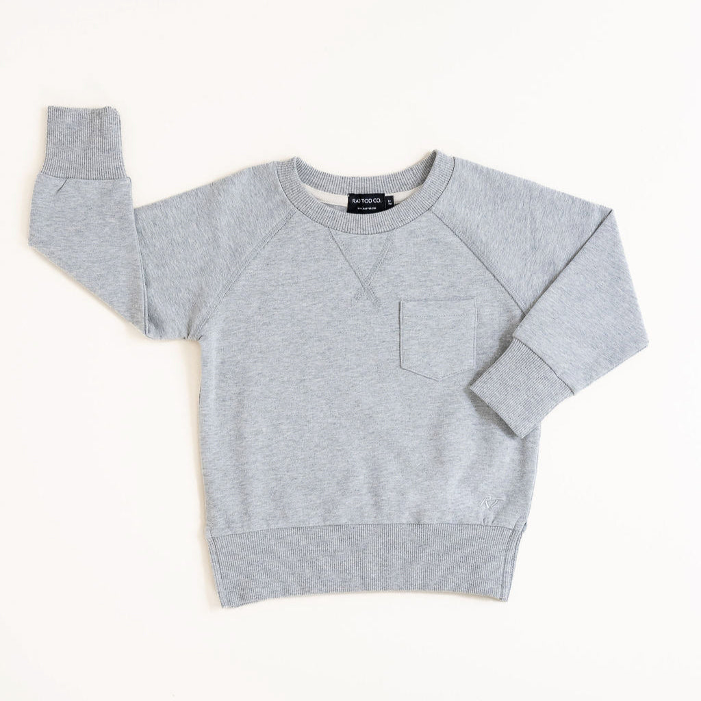 Flat lay of gray toddler crewneck from the Core Collection with oversized, boxy fit and RT embroidered logo.