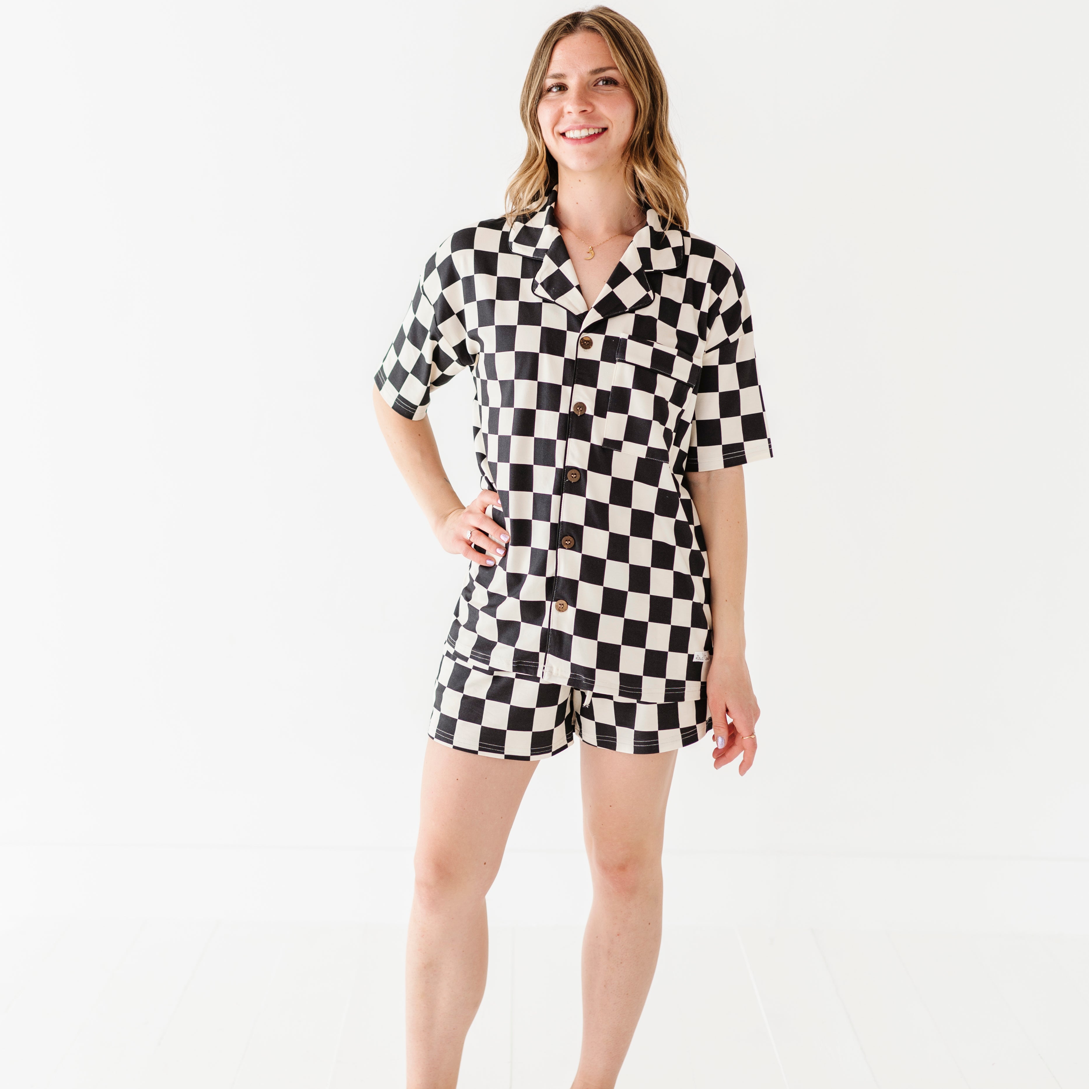 woman wearing Black and white checkered bamboo short sleeve pajama set for women, featuring soft, breathable fabric and a relaxed fit by Rad Toddler.