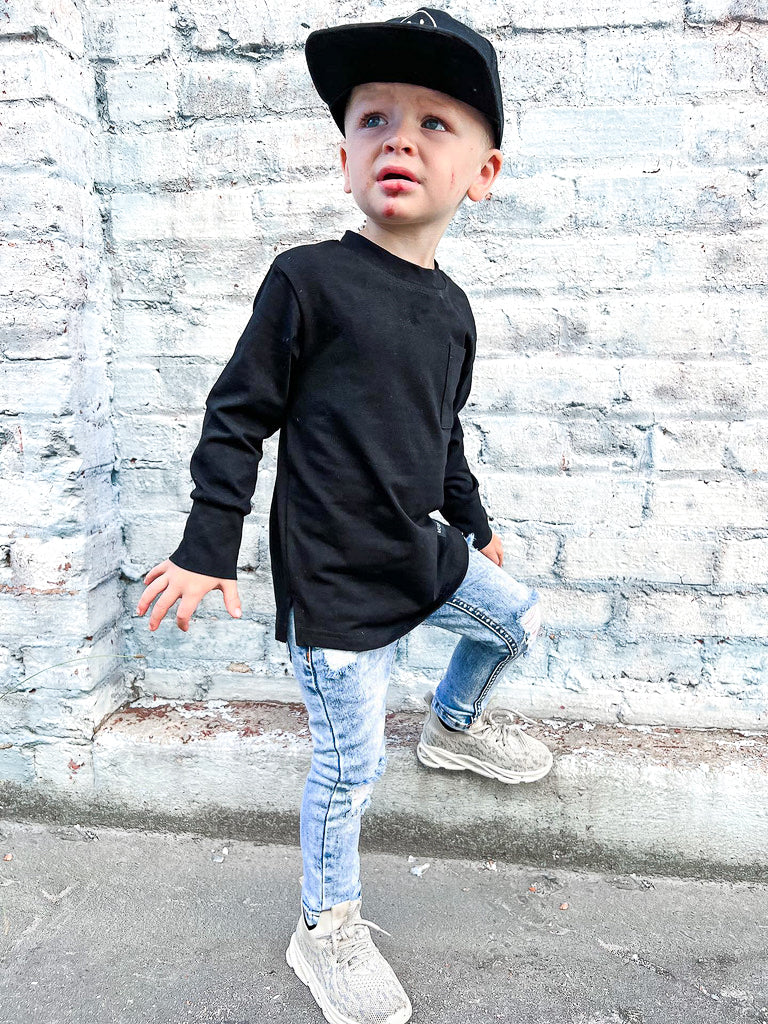 boy wearing black long sleeve tee with a black hat and some cool jeans