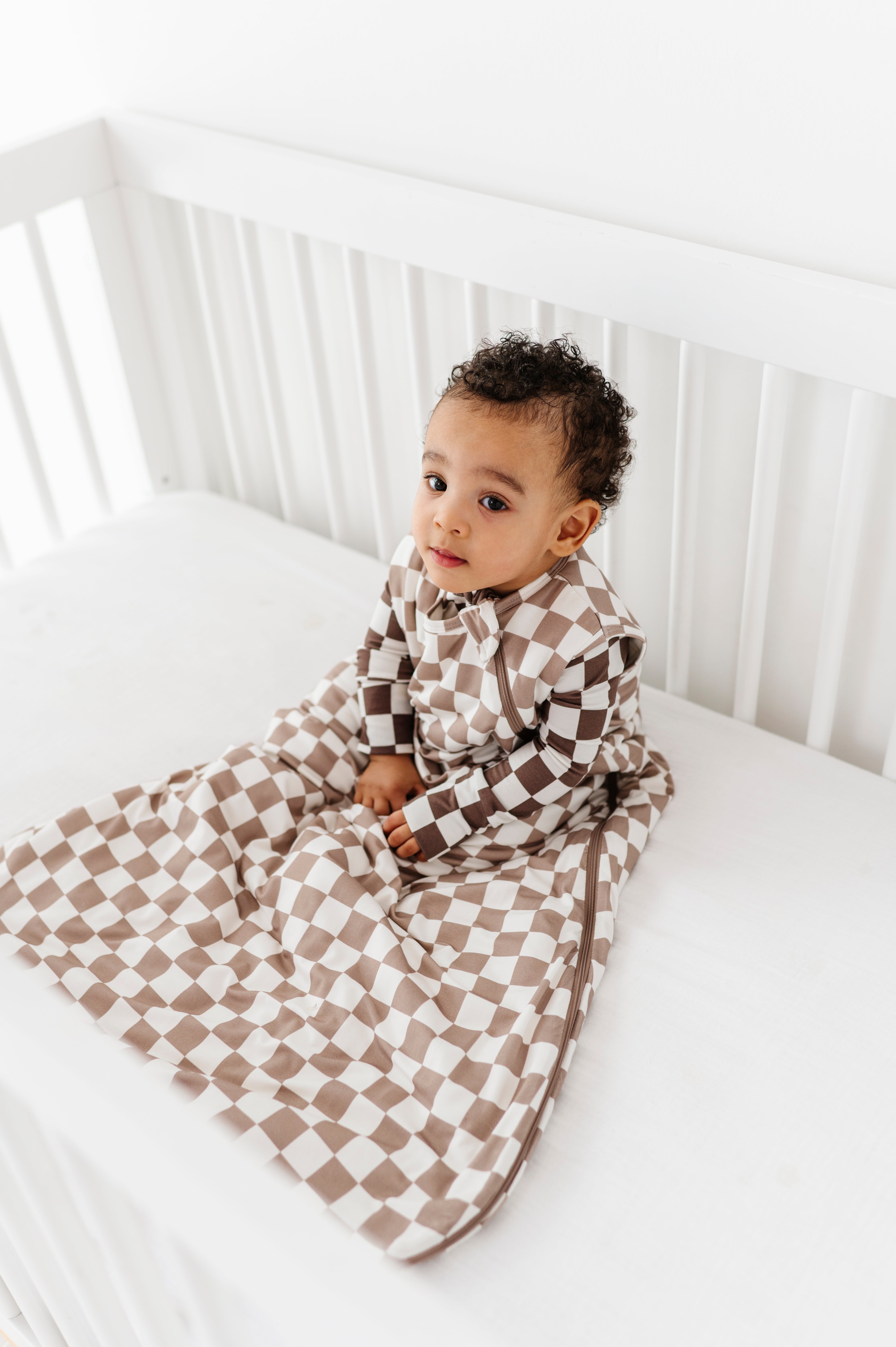 boy wearing Bamboo sleep bag for toddlers aged 6 months to 3 years, featuring soft fabric and a two-way zipper by Rad Toddler.