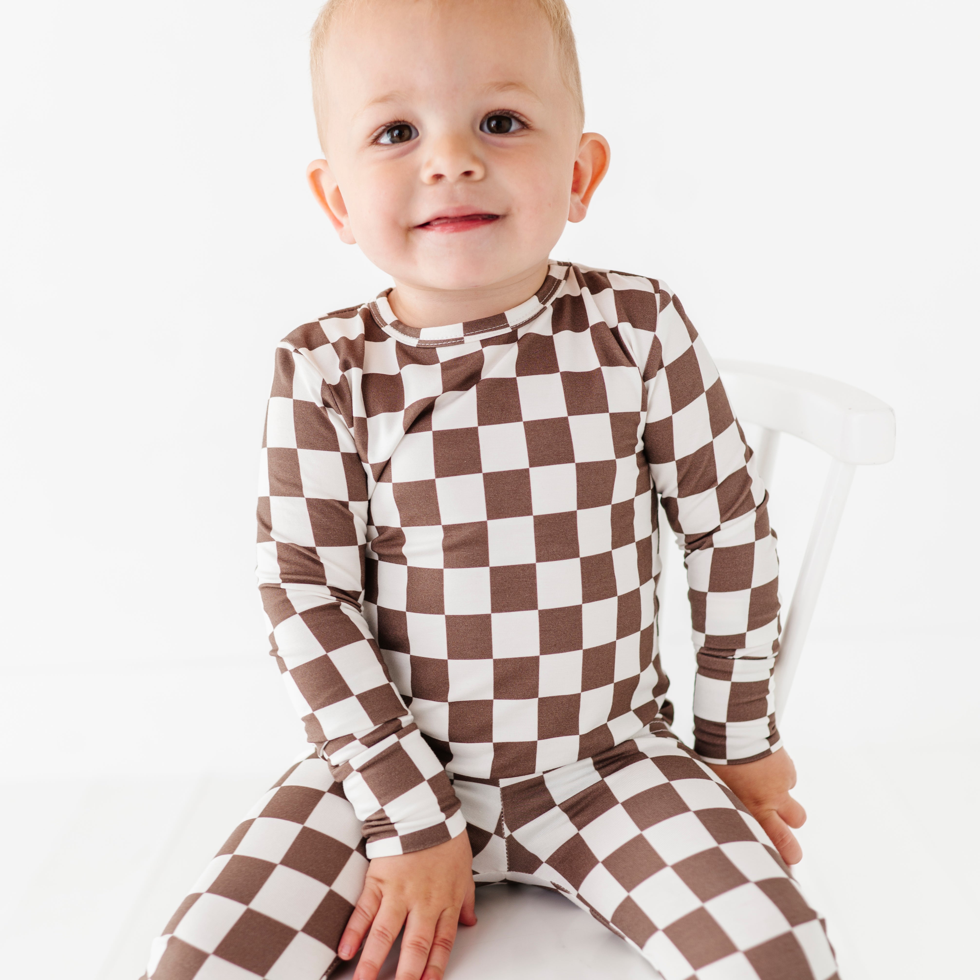boy wearing Bronze and white checkered bamboo 2-piece pajama set for toddlers, featuring a short sleeve top and elastic waistband pants by Rad Toddler.