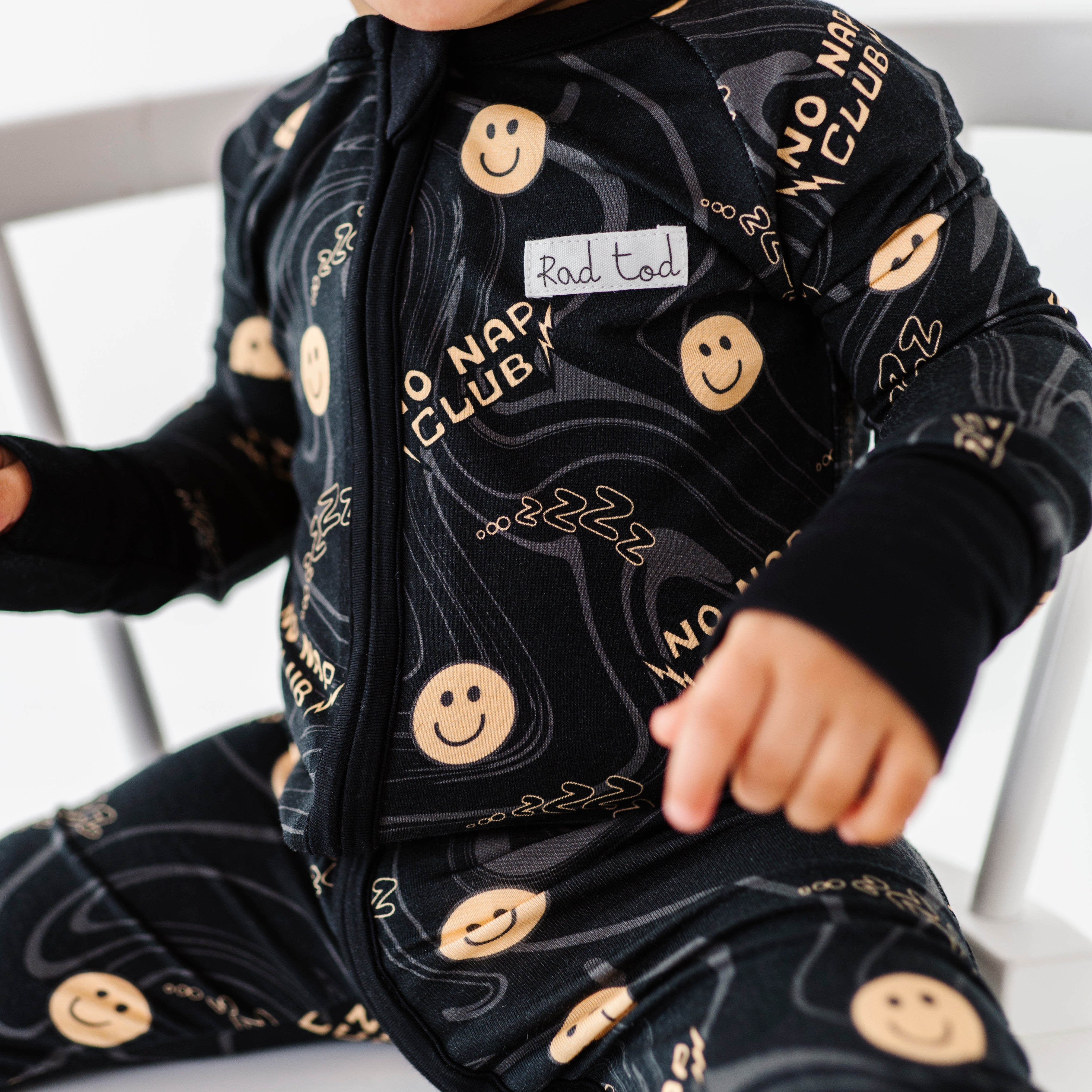 Black bamboo onesie with smiley face graphics and wavy lines for active toddlers