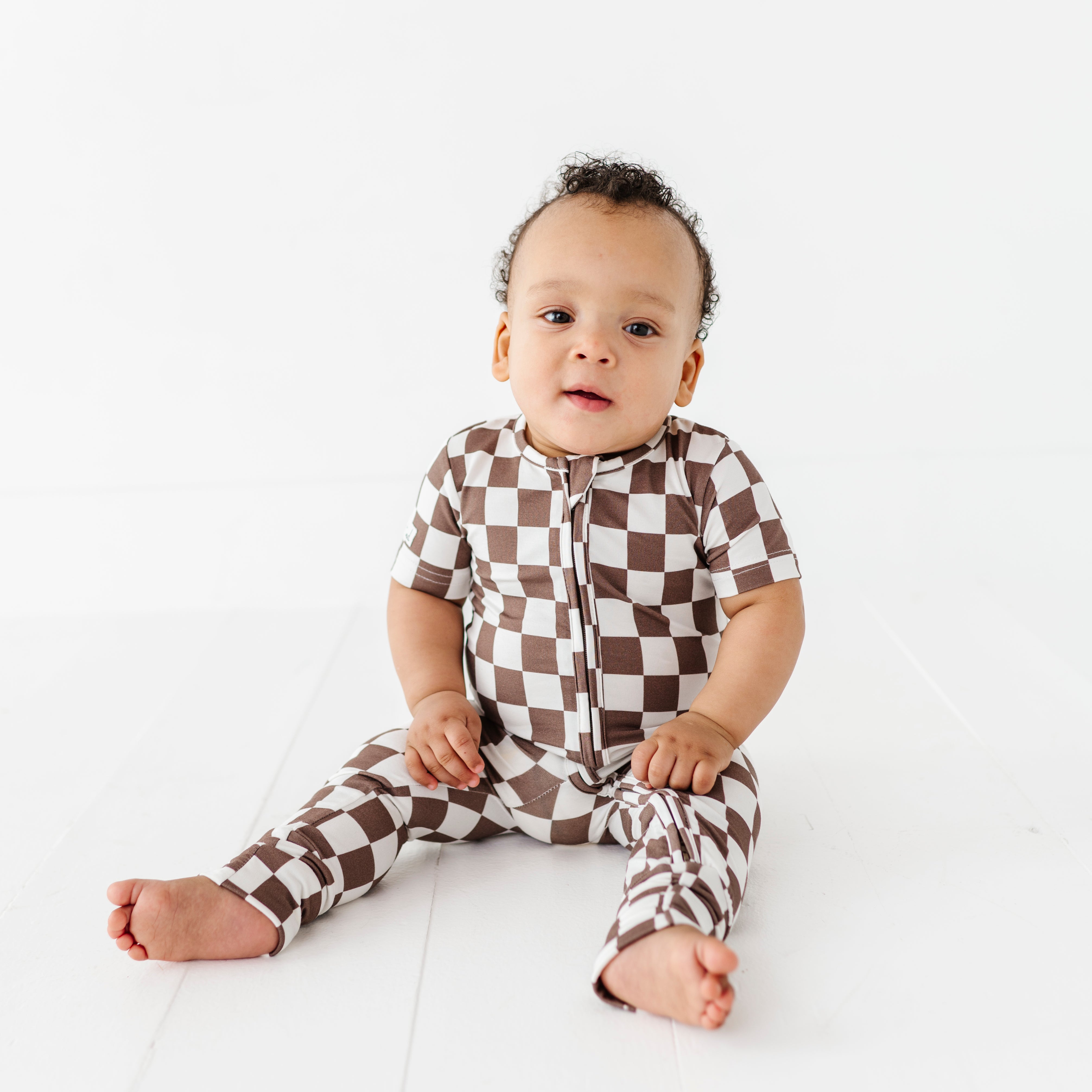 boy wearing Bronze and white checkered bamboo onesie for toddlers, featuring a two-way zipper and optional foldover footies by Rad Toddler.