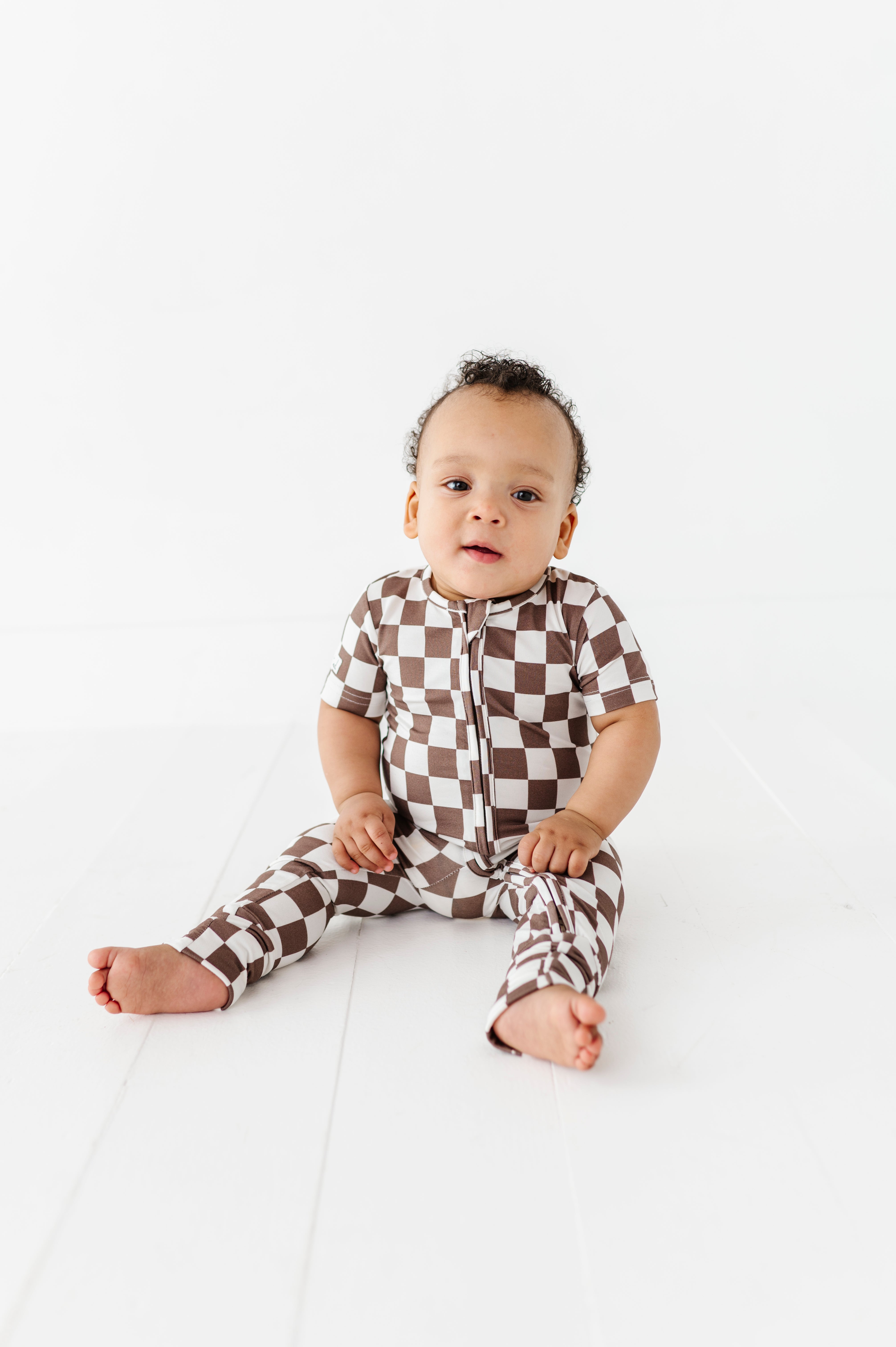 boy wearing Bronze and white checkered bamboo onesie for toddlers, featuring a two-way zipper and optional foldover footies by Rad Toddler.