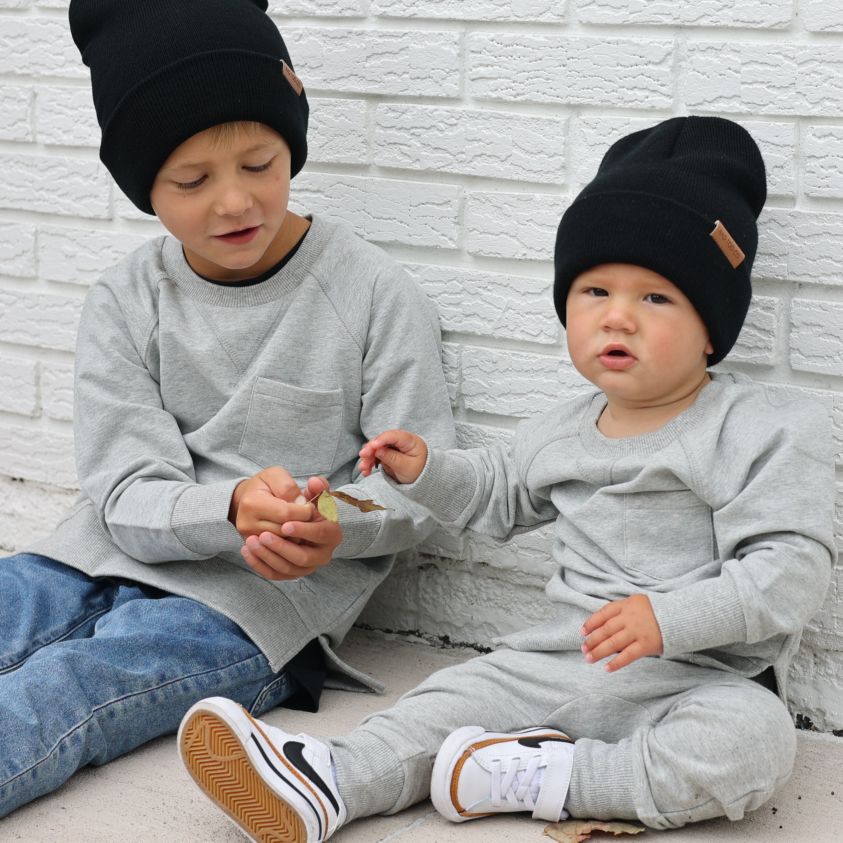 brothers wearing gray Core Collection toddler crewneck with oversized fit, standing outdoors.