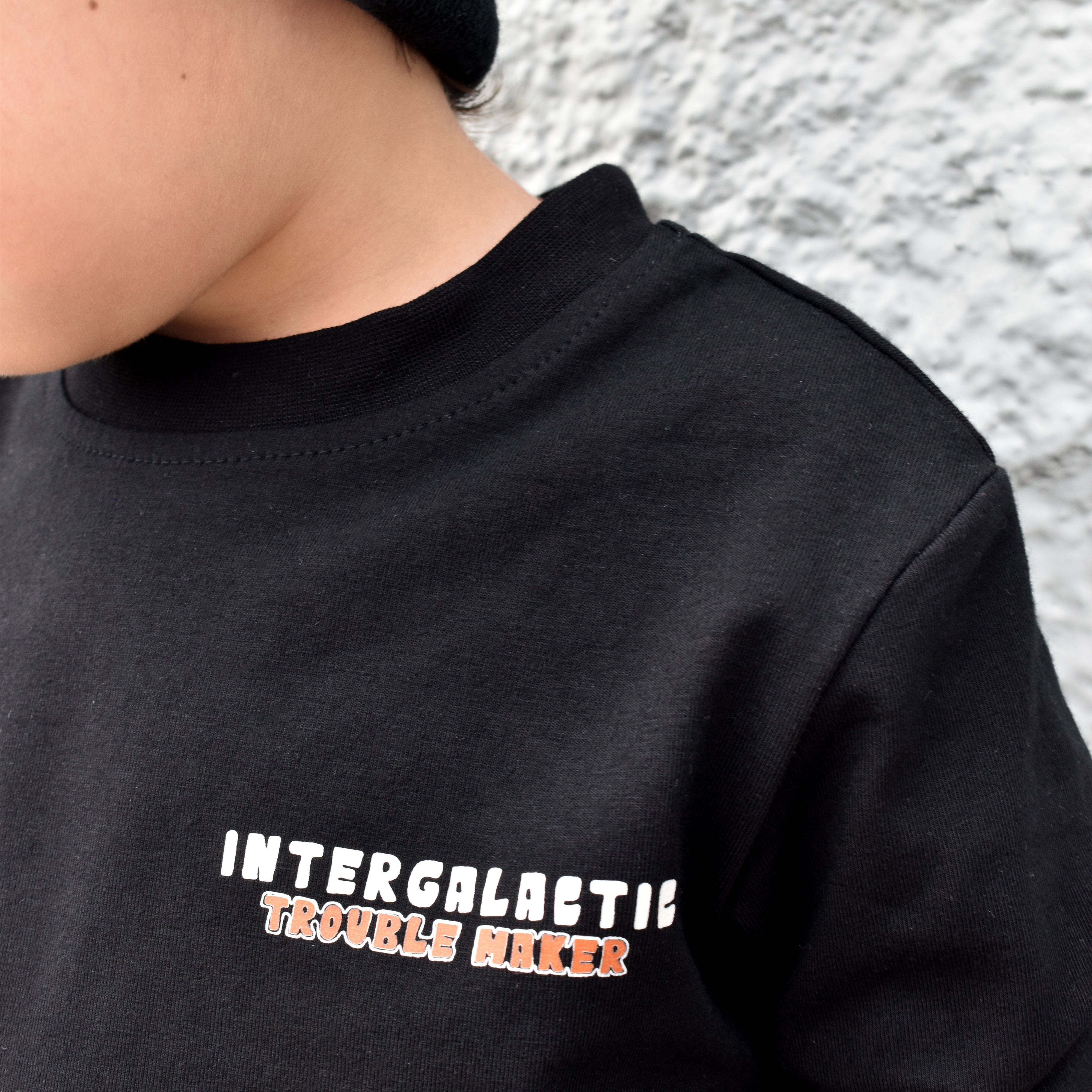 Lifestyle photo of boy wearing black Intergalactic Troublemaker long sleeve
