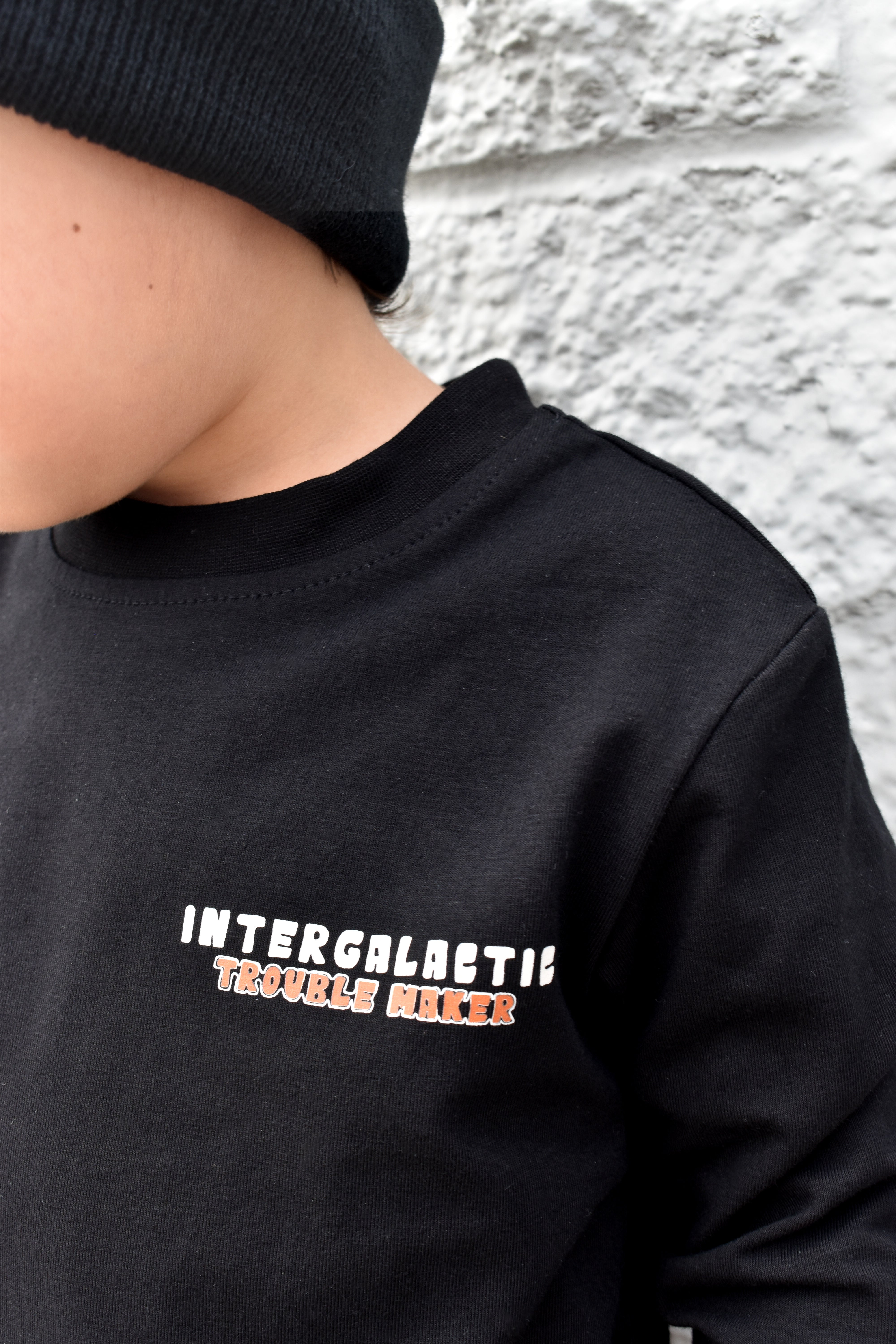 Lifestyle photo of boy wearing black Intergalactic Troublemaker long sleeve