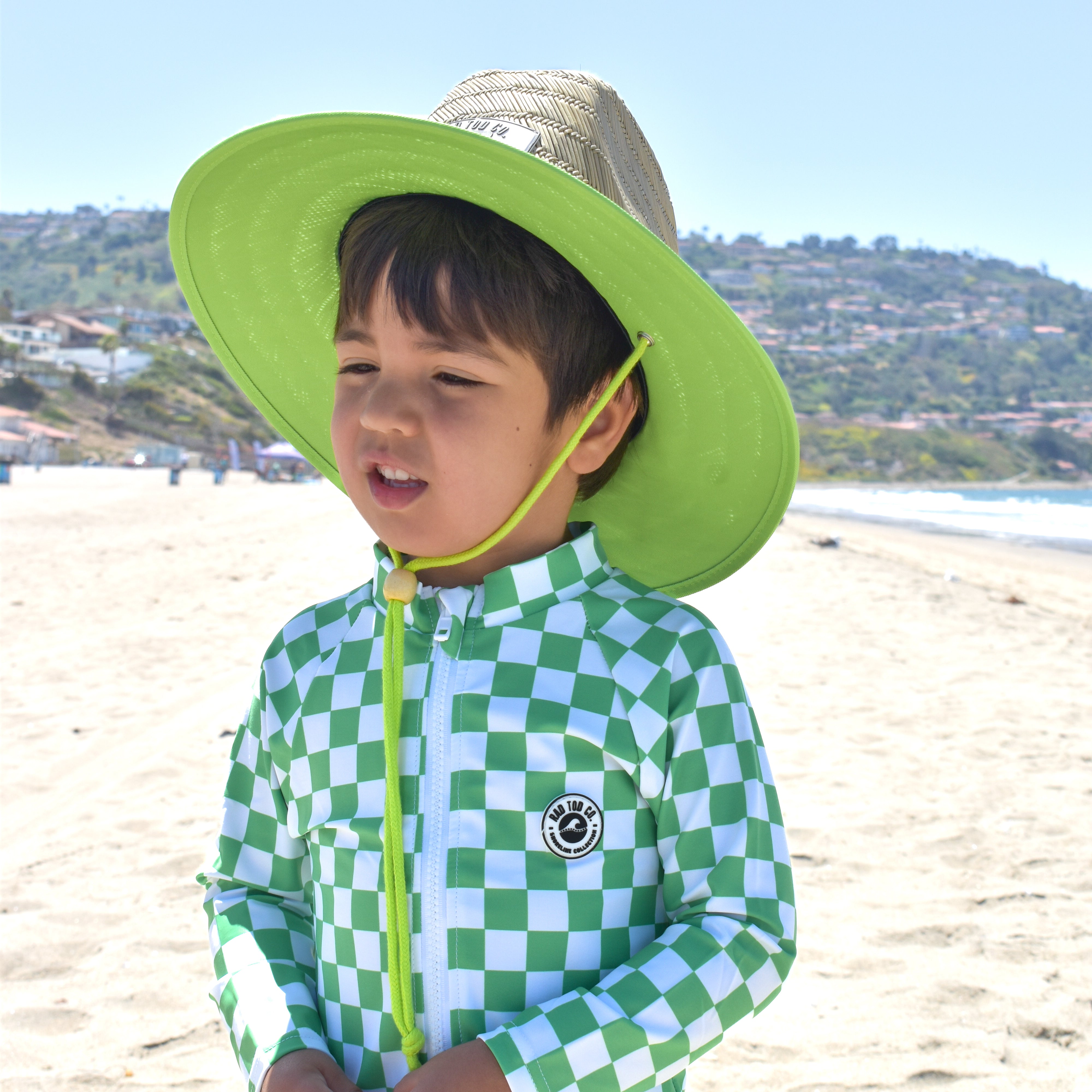 Stylish kids rashguard onesie green checker surf style and straw hat by rad toddler