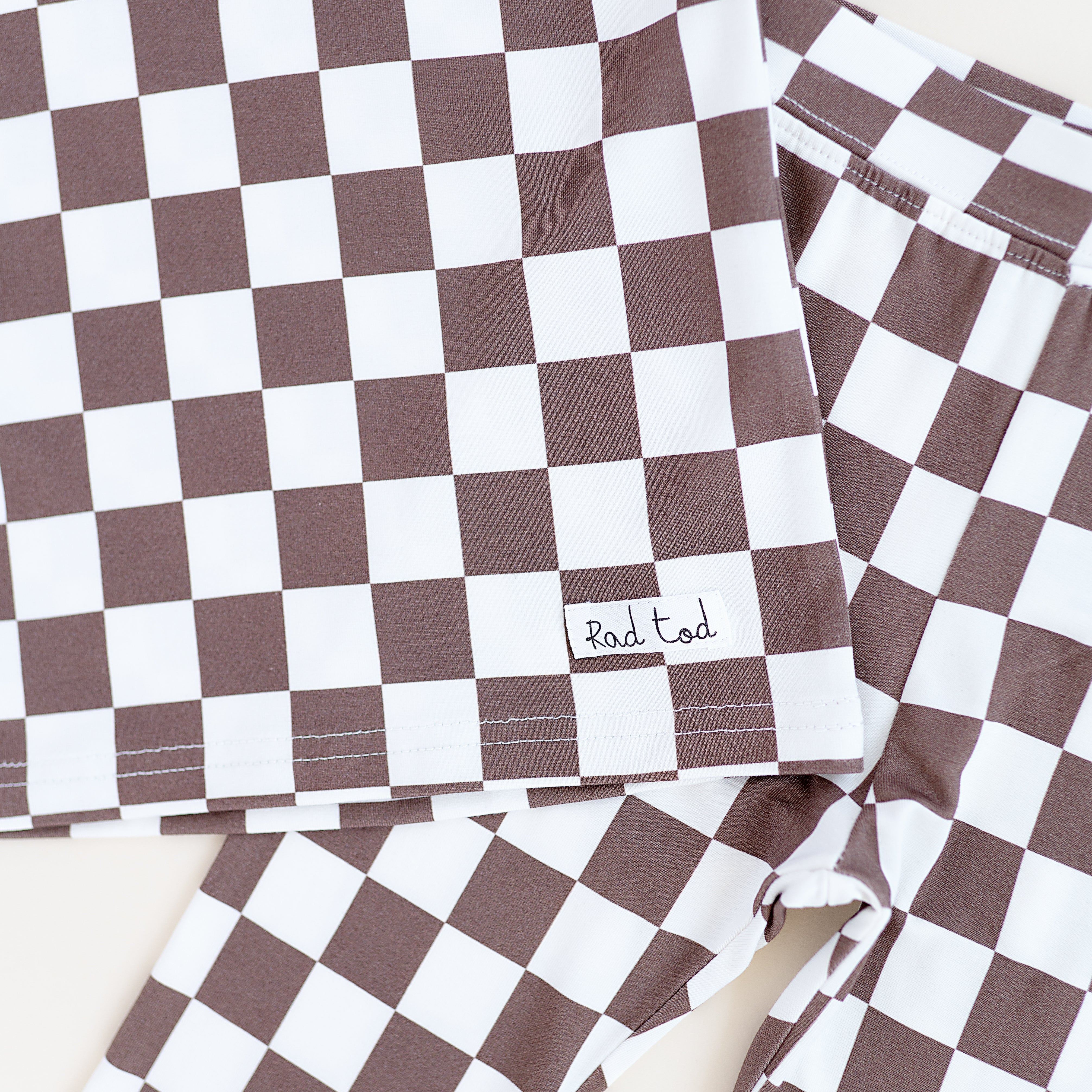 details on Bronze and white checkered bamboo 2-piece pajama set for toddlers, featuring a short sleeve top and elastic waistband pants by Rad Toddler.
