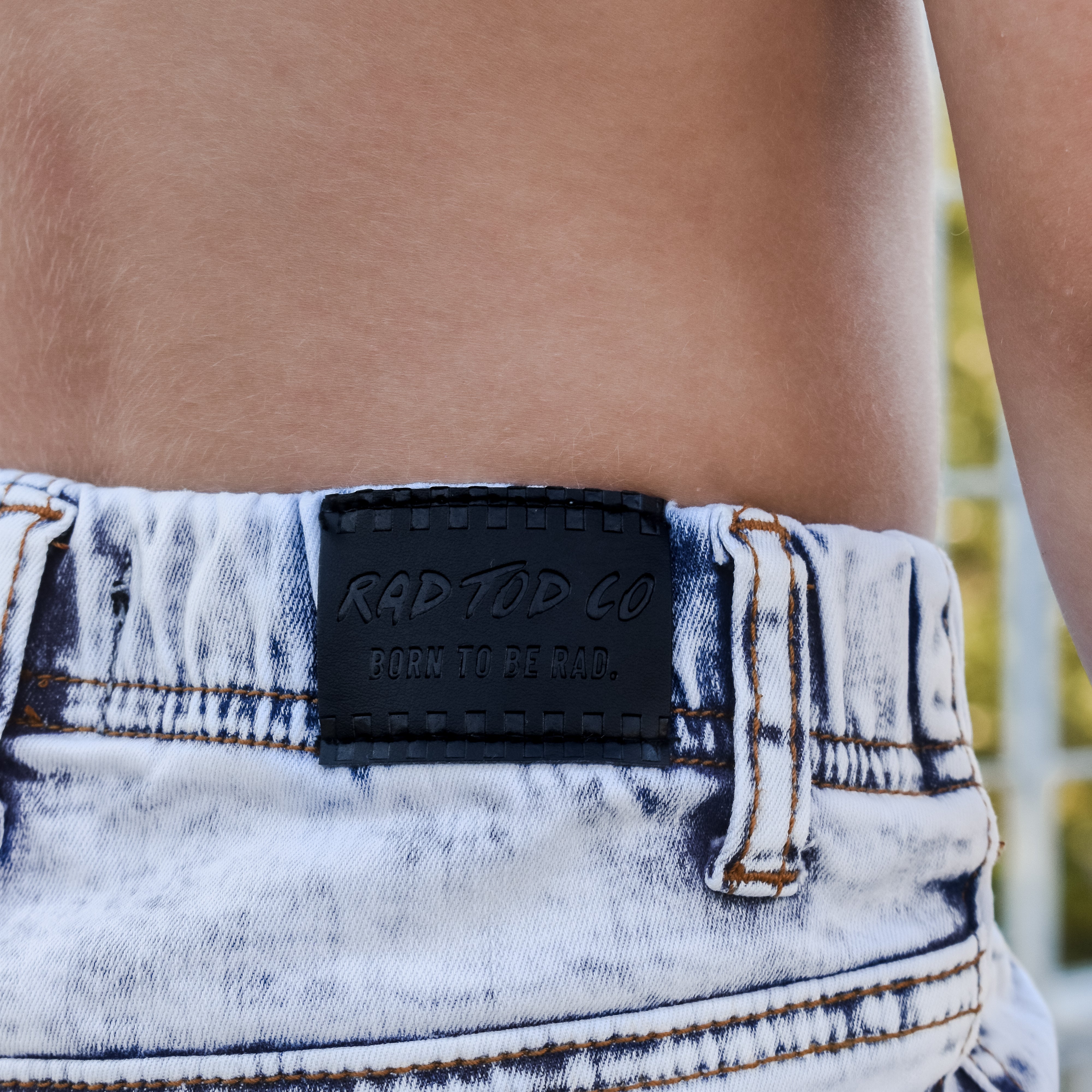 Close-up of a denim product with a brand label on a blurred background