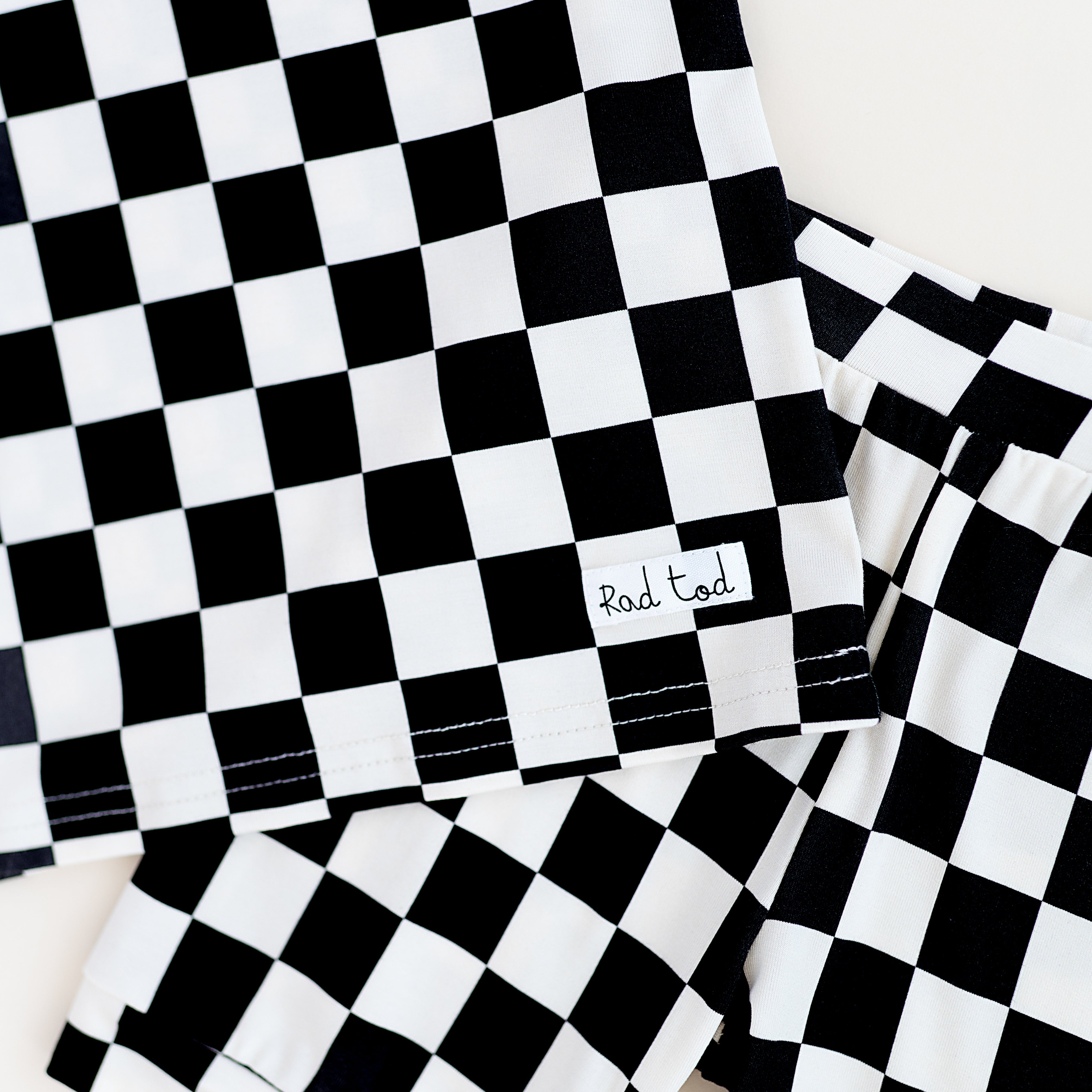 details on Black and white checkered bamboo short sleeve pajama set for toddlers, featuring a soft, breathable fabric and stretchy waistband by Rad Toddler.