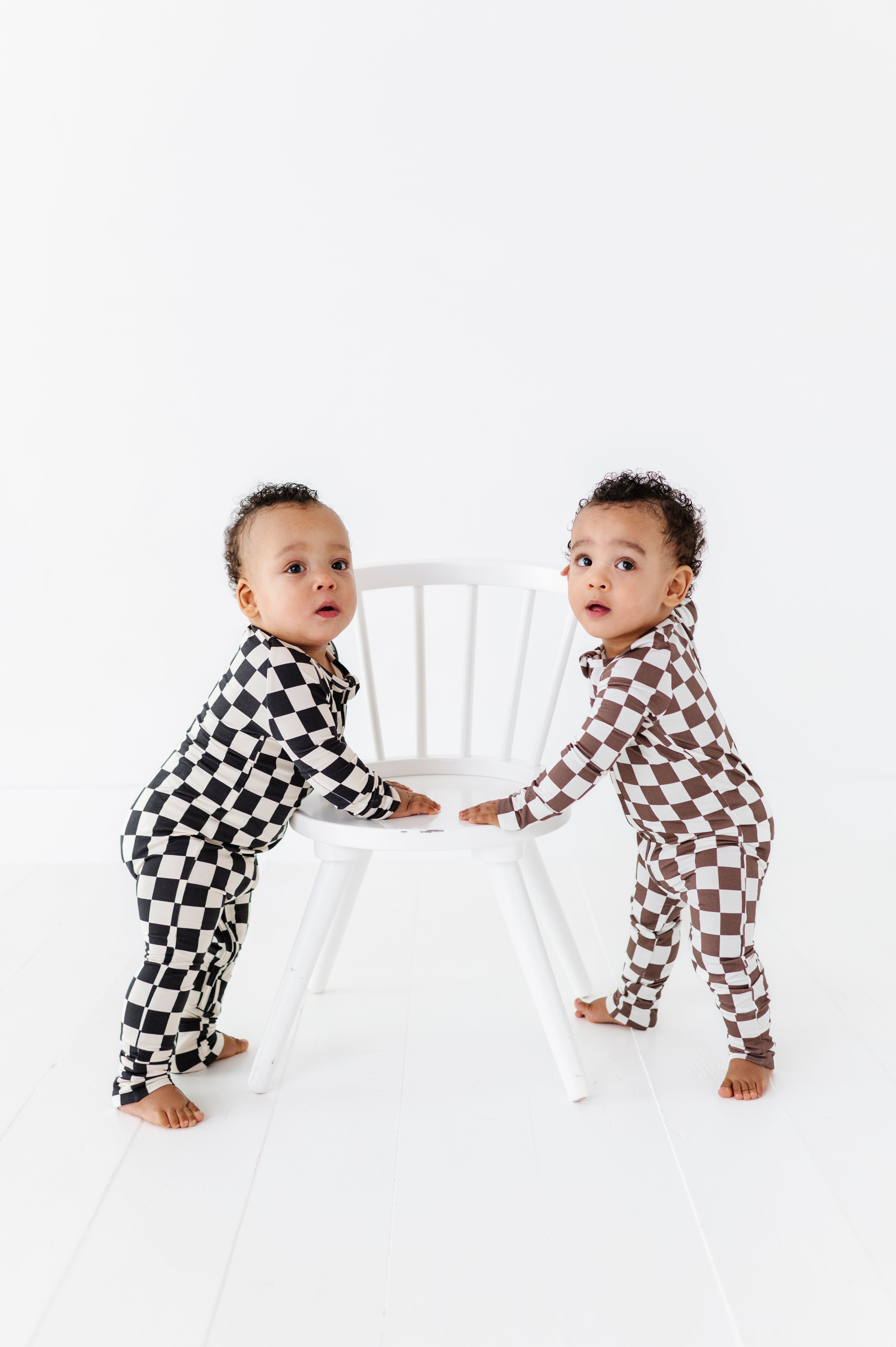 2 boys wearing Bronze and white checkered bamboo pajamas for toddlers, featuring a two-way zipper and foldover footies by Rad Toddler.