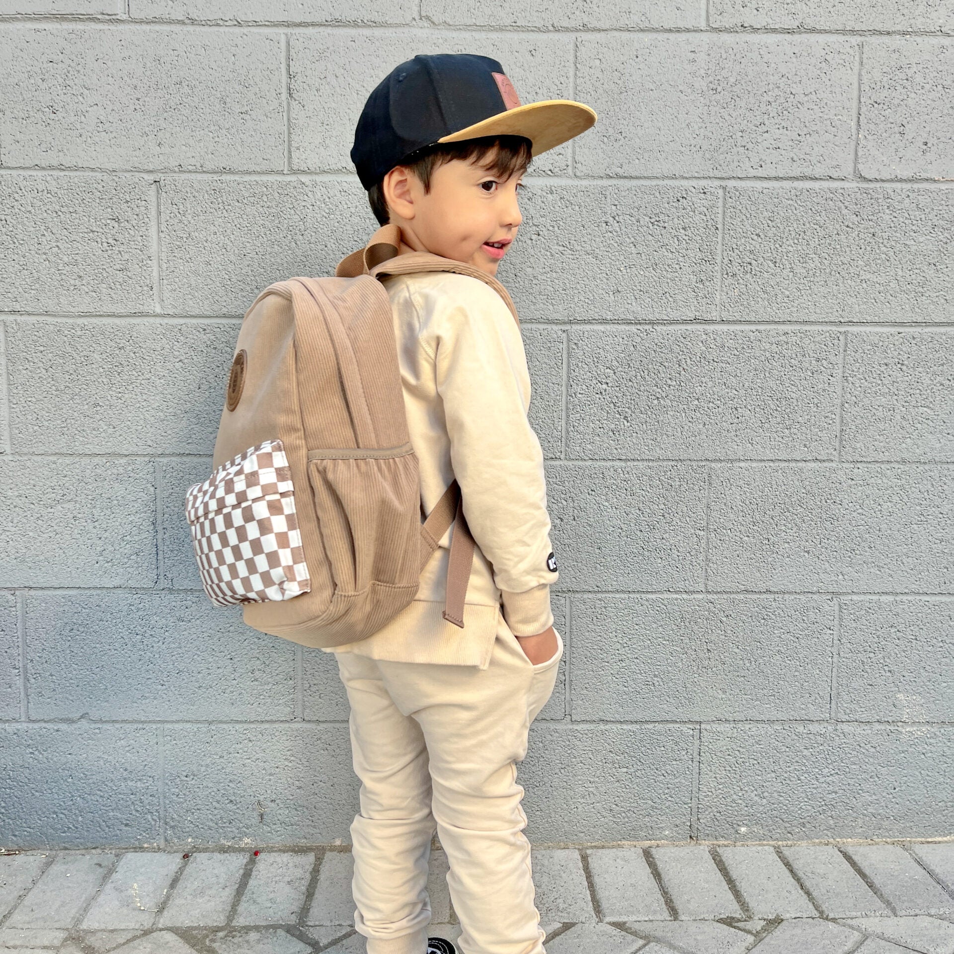 toddler wearing dune toddler backpack with checker accent and vegan leather