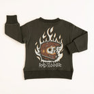 Dark green crewneck sweatshirt with brown helmet, flaming skull, and bold graphic design laid flat