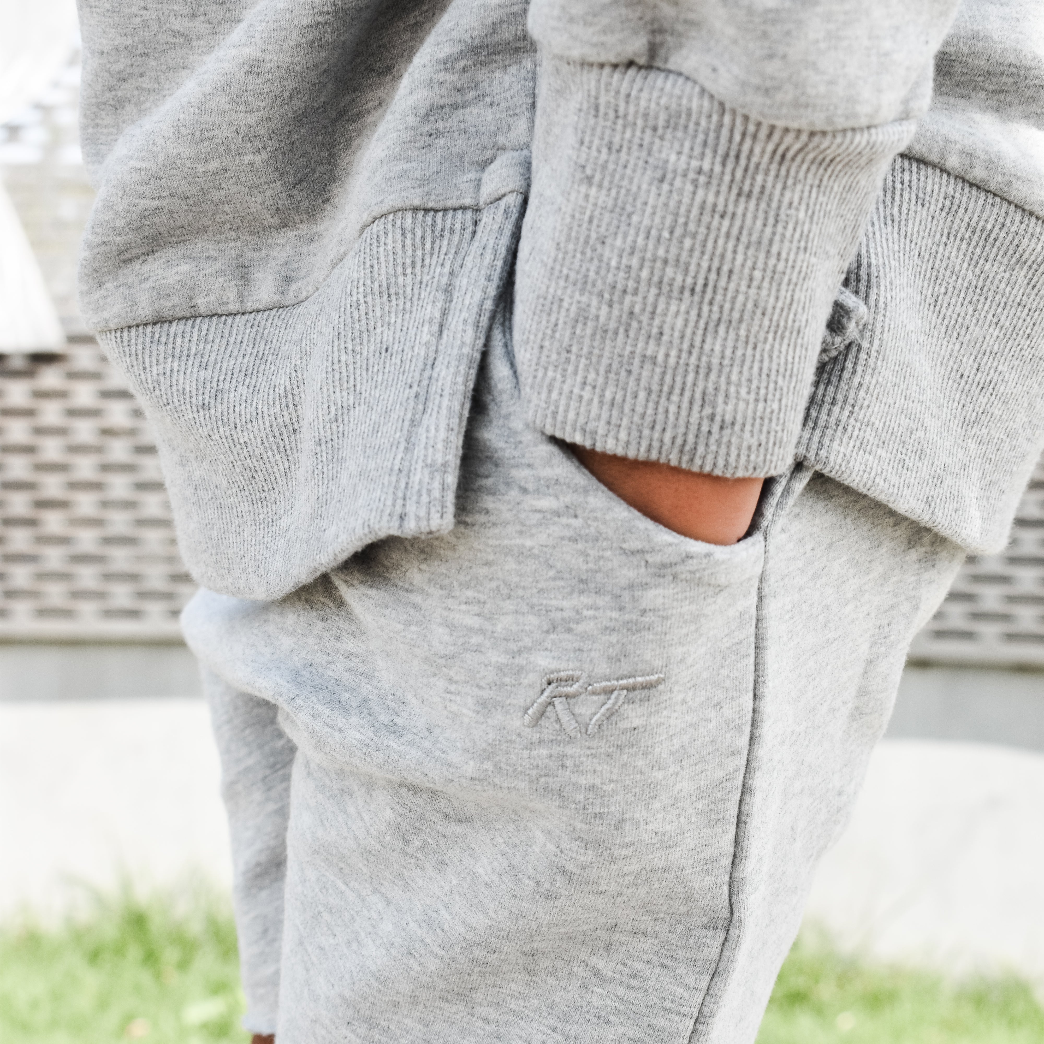 Young boy wearing gray Core Collection toddler shorts, standing outdoors and showcasing the relaxed, above-the-knee fit.