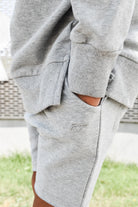 Young boy wearing gray Core Collection toddler shorts, standing outdoors and showcasing the relaxed, above-the-knee fit.