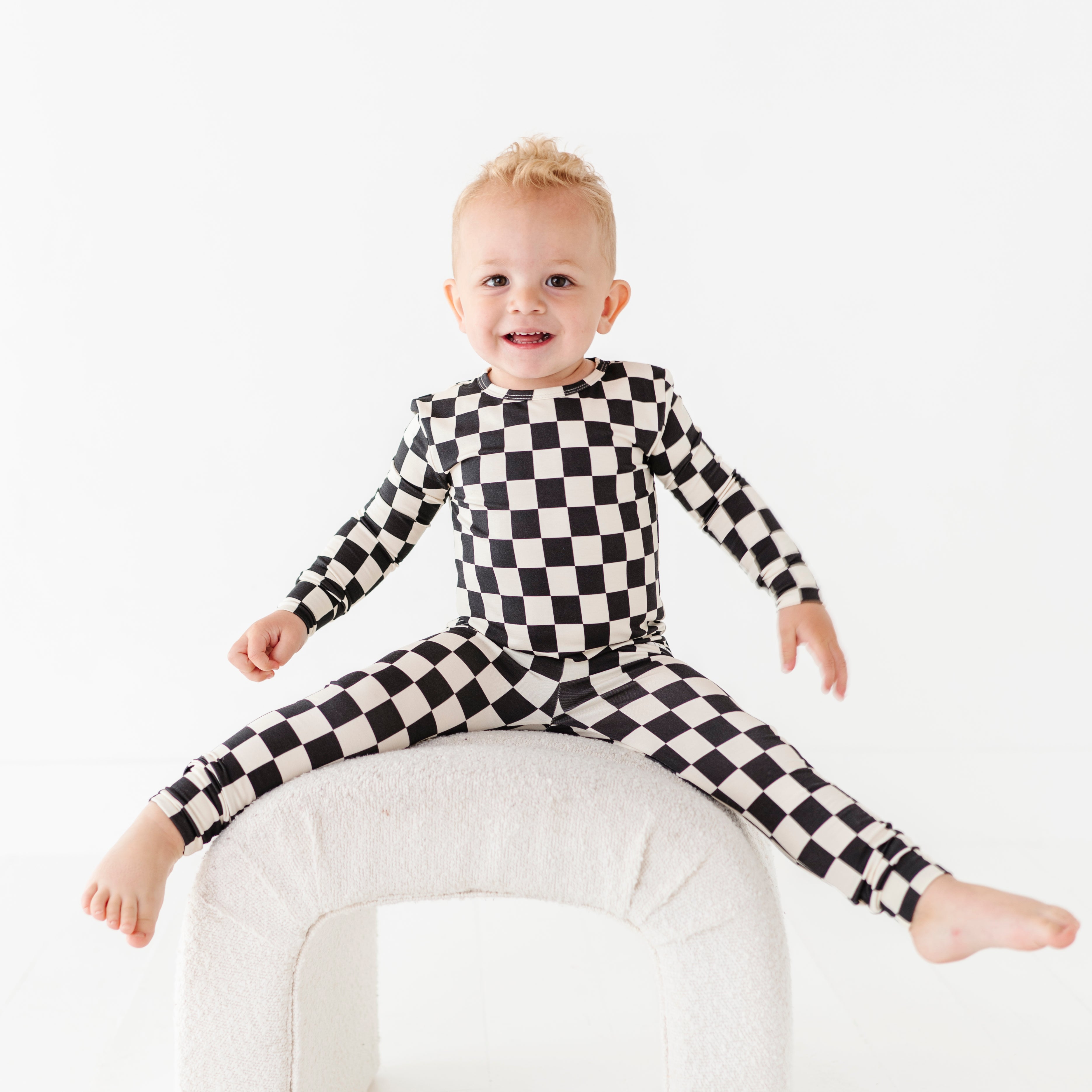 little boy enjoying Black checkered 2-piece pajamas for toddlers and kids, featuring a comfy fit and elastic waistband by Rad Toddler.