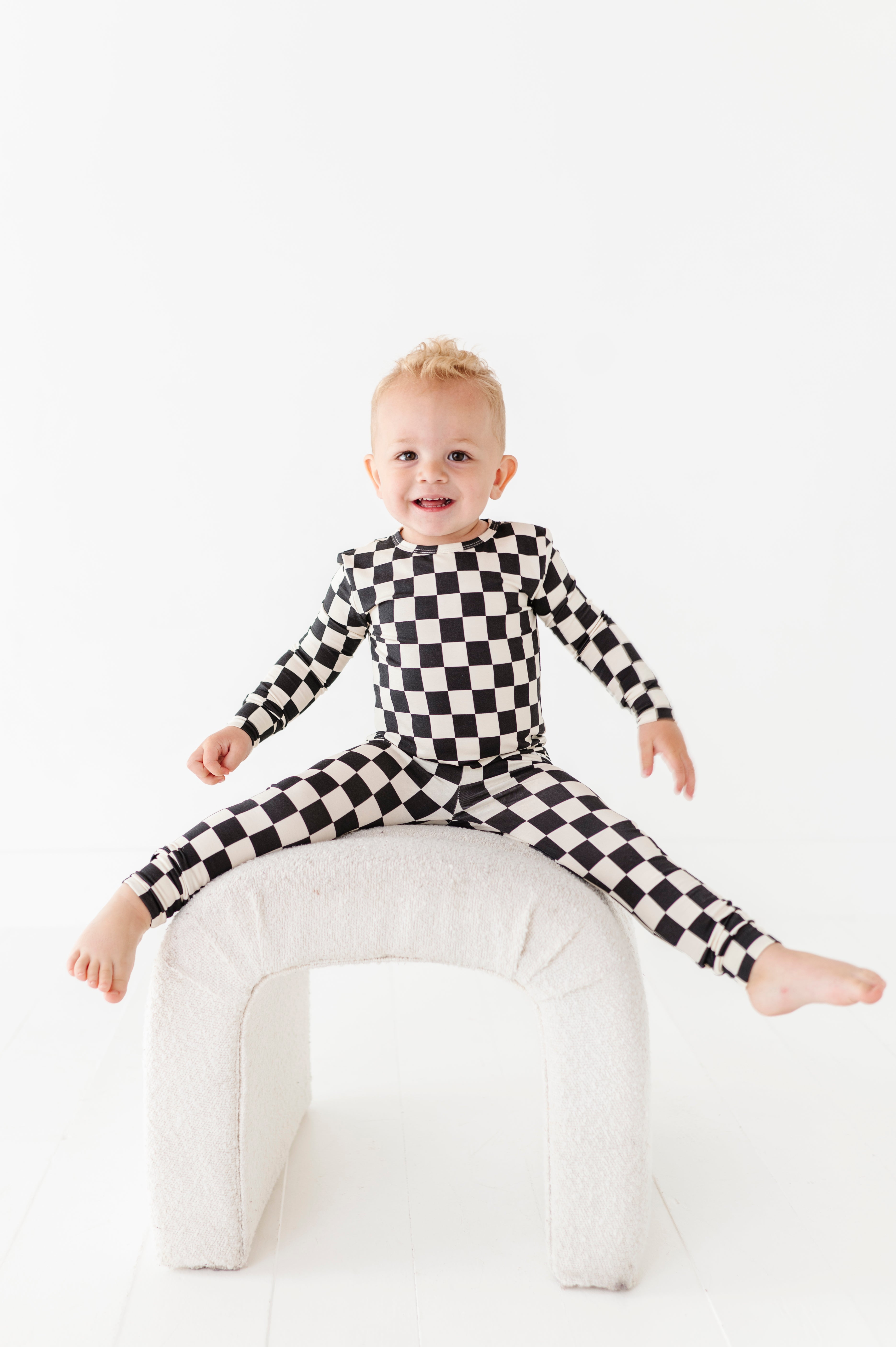 little boy enjoying Black checkered 2-piece pajamas for toddlers and kids, featuring a comfy fit and elastic waistband by Rad Toddler.