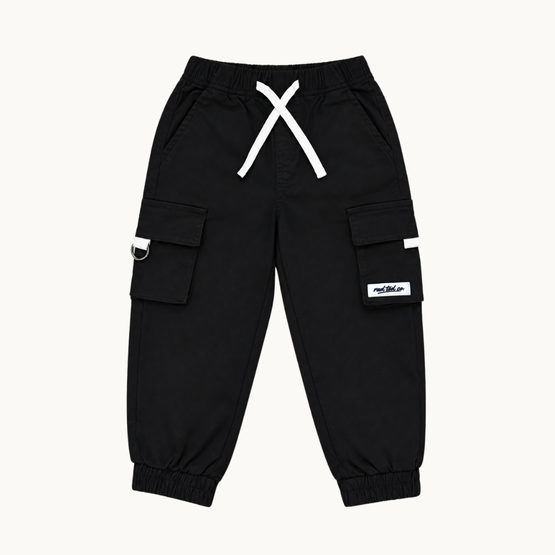 Black cargo jogger pants with white drawstrings, side cargo pockets, and a small white brand patch on the left leg, shown flat on a light cream background.