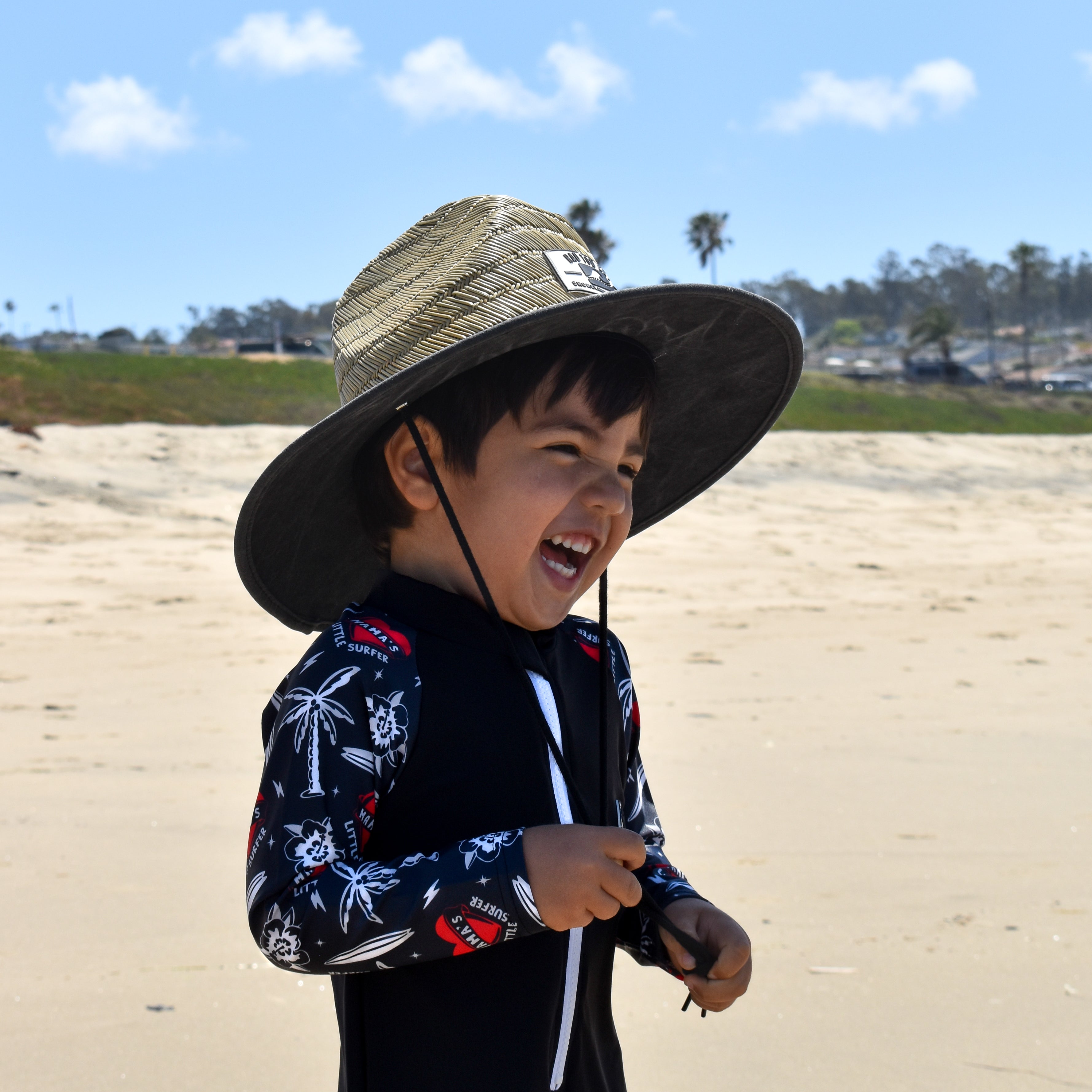 Rashguard onesie paired with staw hat for sun protection
