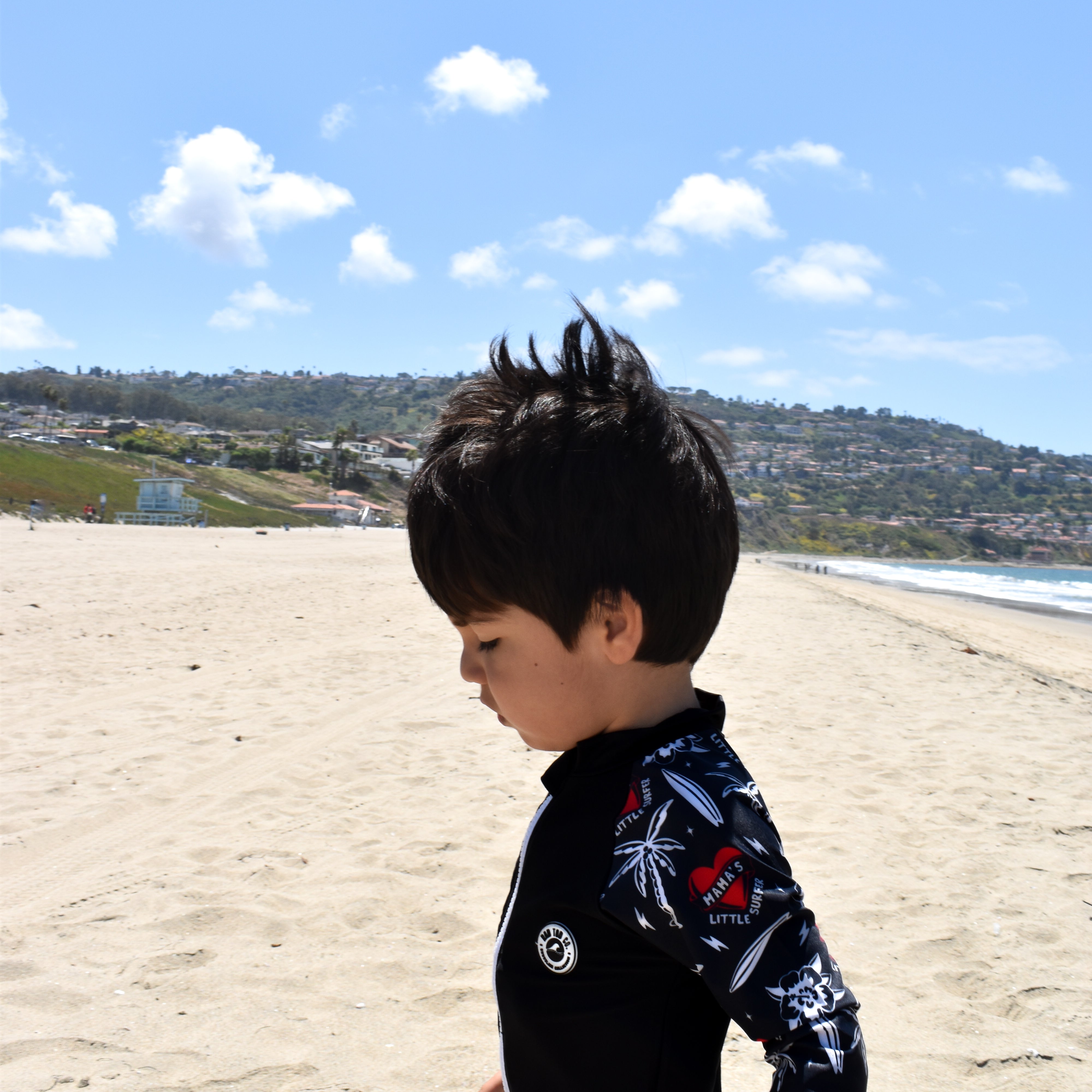 Child wearing rashguard onesie at the beach by rad toddler