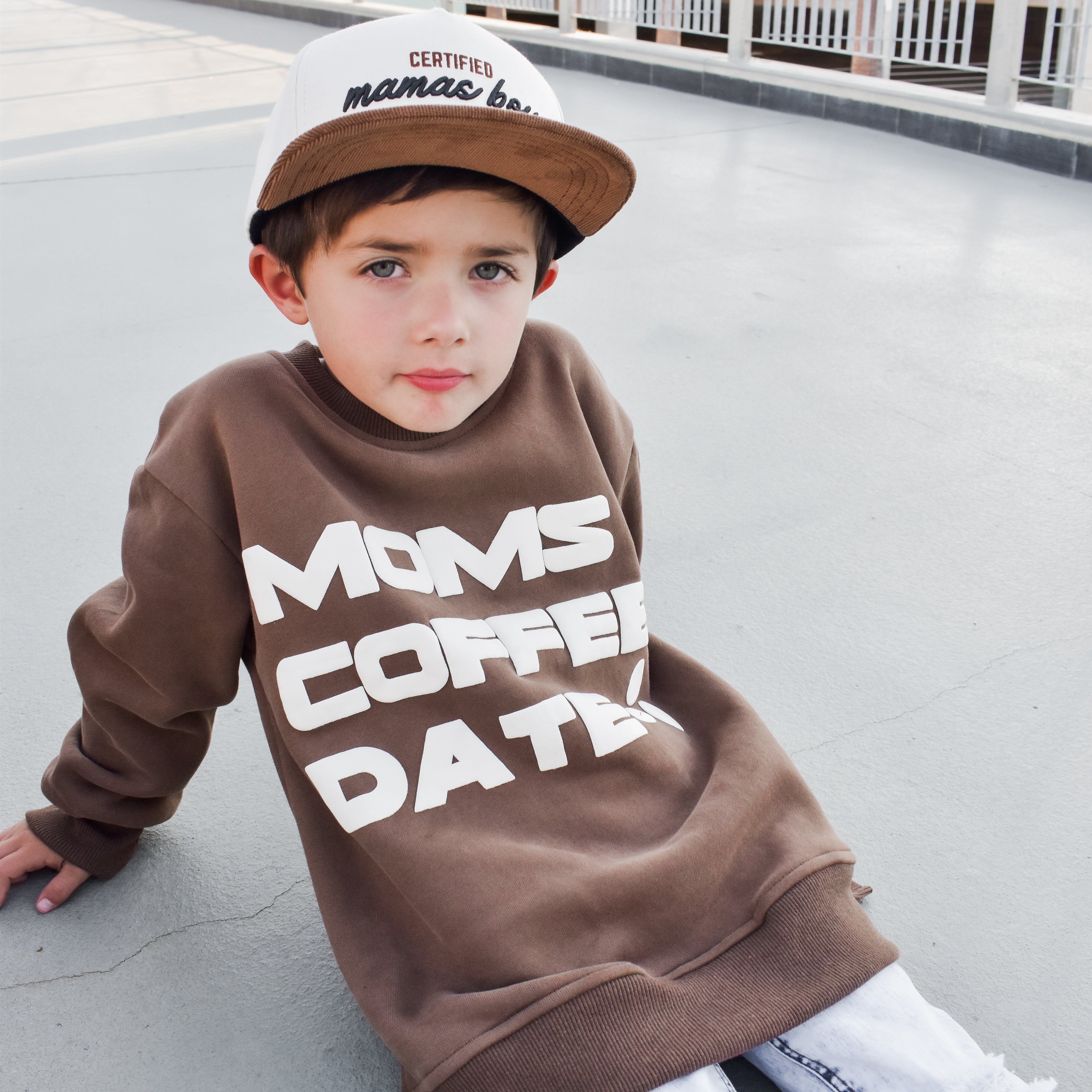 boy wearing coffee-brown “Mom’s Coffee Date” crewneck with bold off-white lettering, slightly oversized fit.