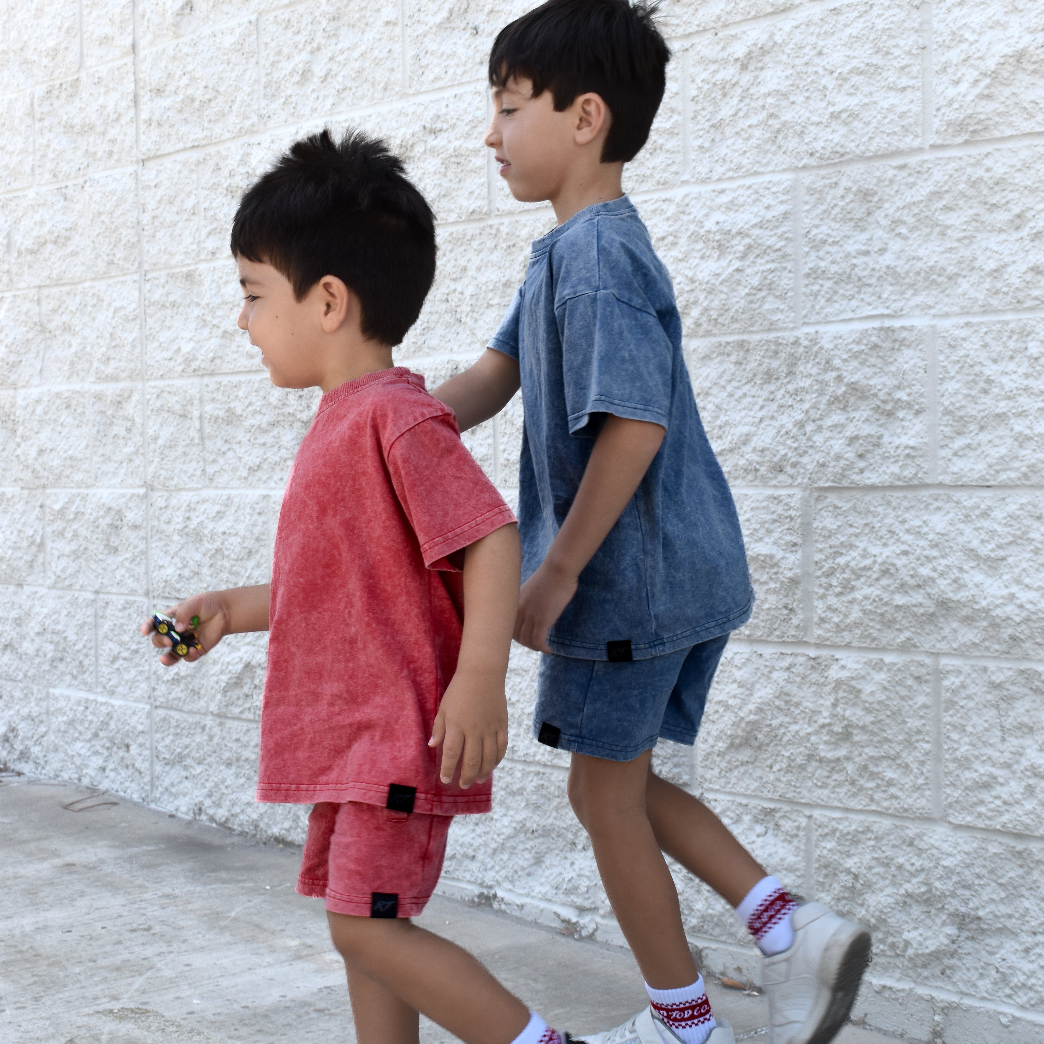 two boys wearing muted red and vintage blue sets by rad toddler