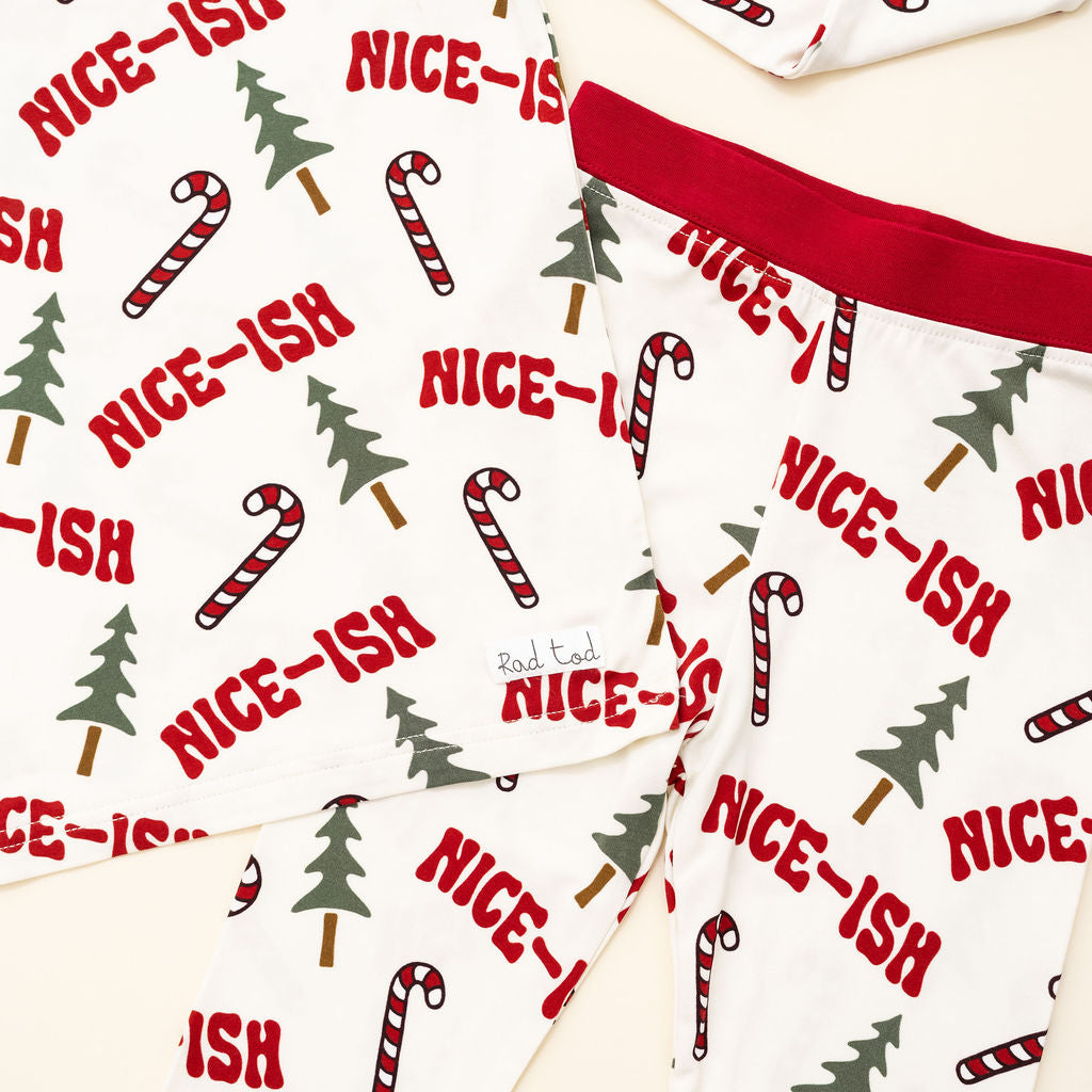 Christmas-themed fabric with candy canes, trees, and 'NICE-ISH' text on a white background.
