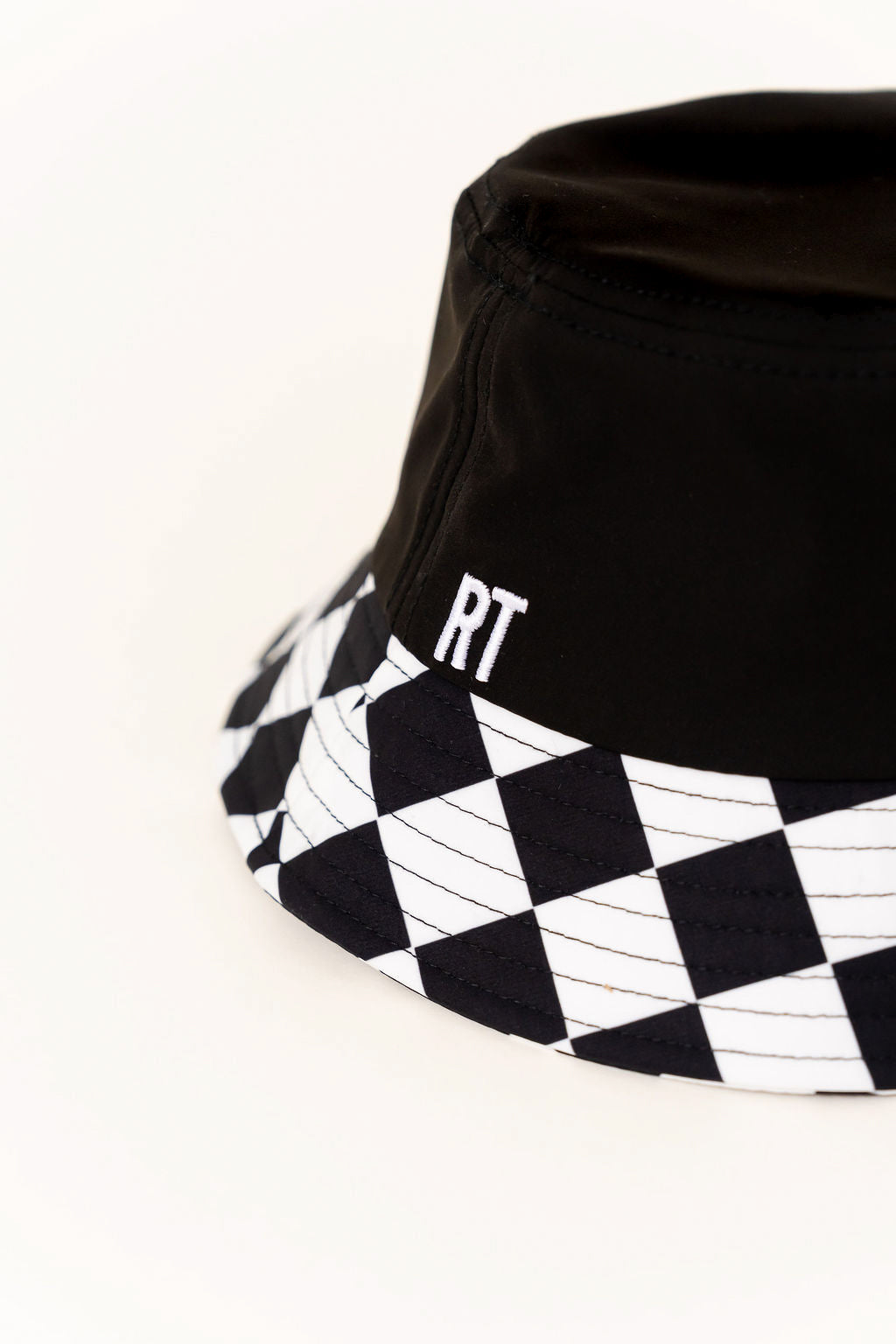 Black bucket hat with checkered brim and 'RT' logo on a white background