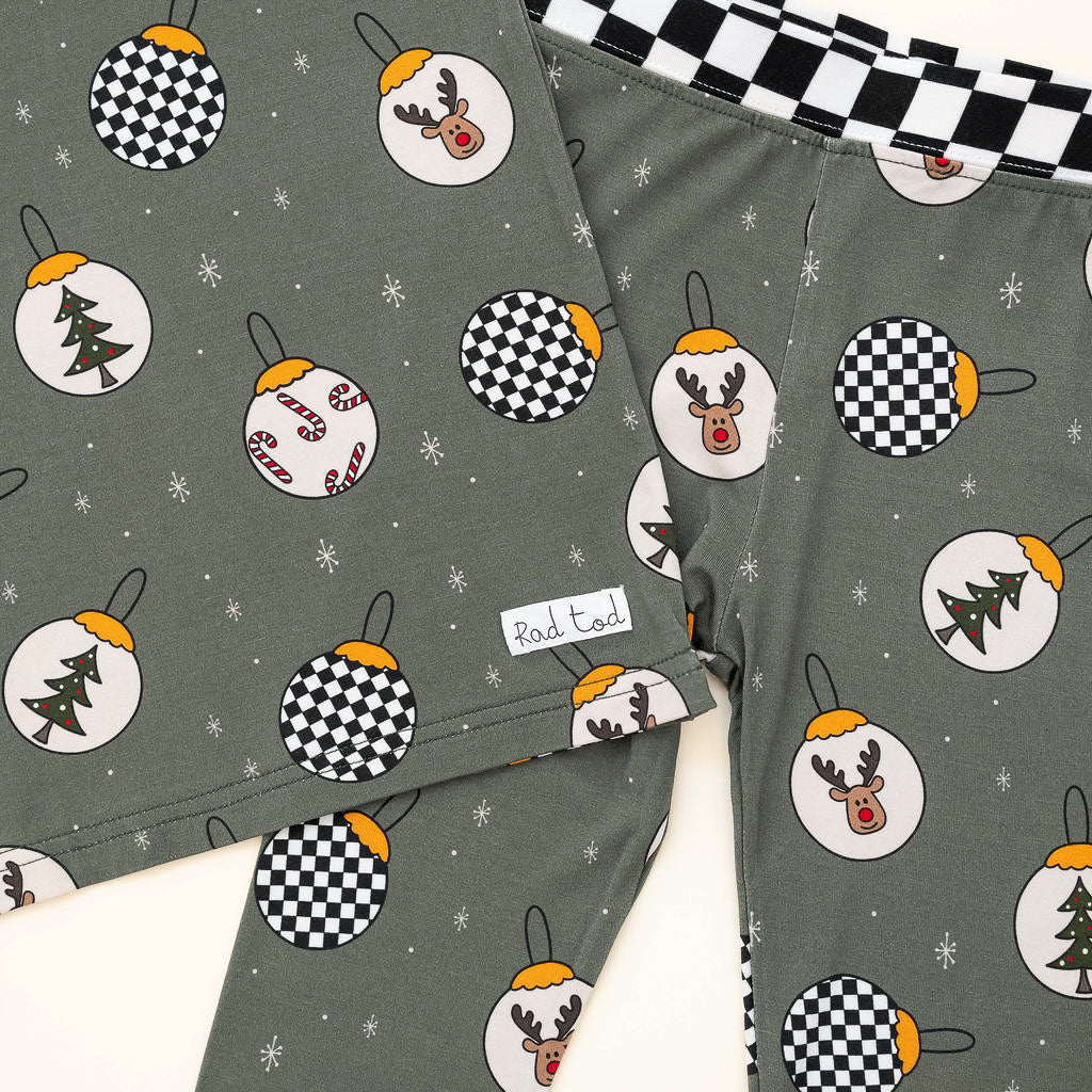 Pine green kids holiday pajamas with festive ornament design close up