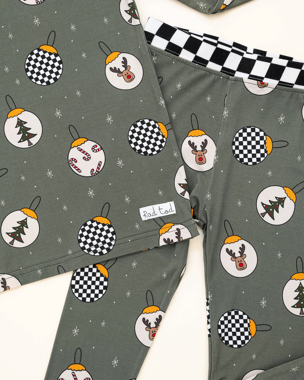 Pine green kids holiday pajamas with festive ornament design close up