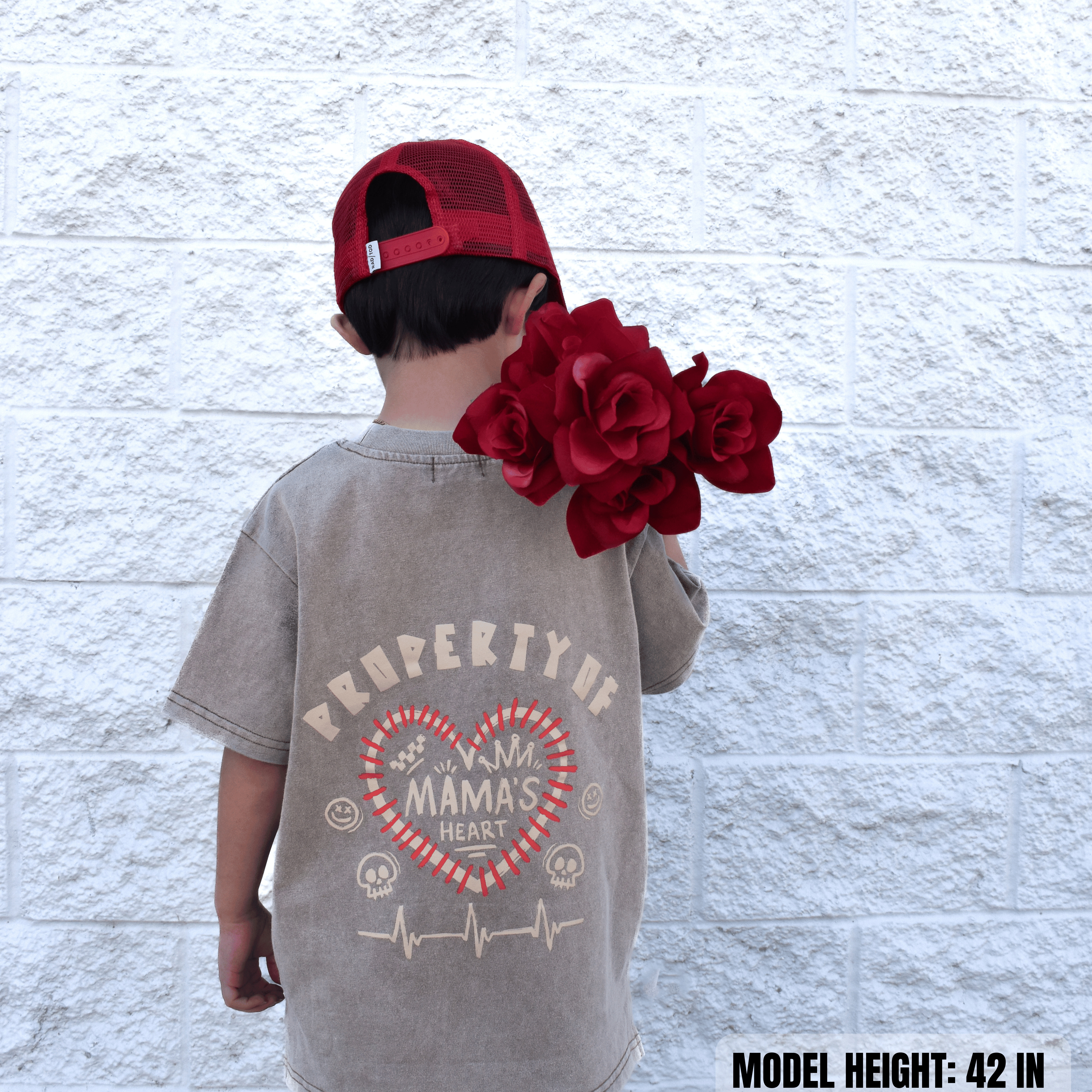 Kid wearing Property of Mama’s Heart acid wash beige t-shirt with flowers in hand