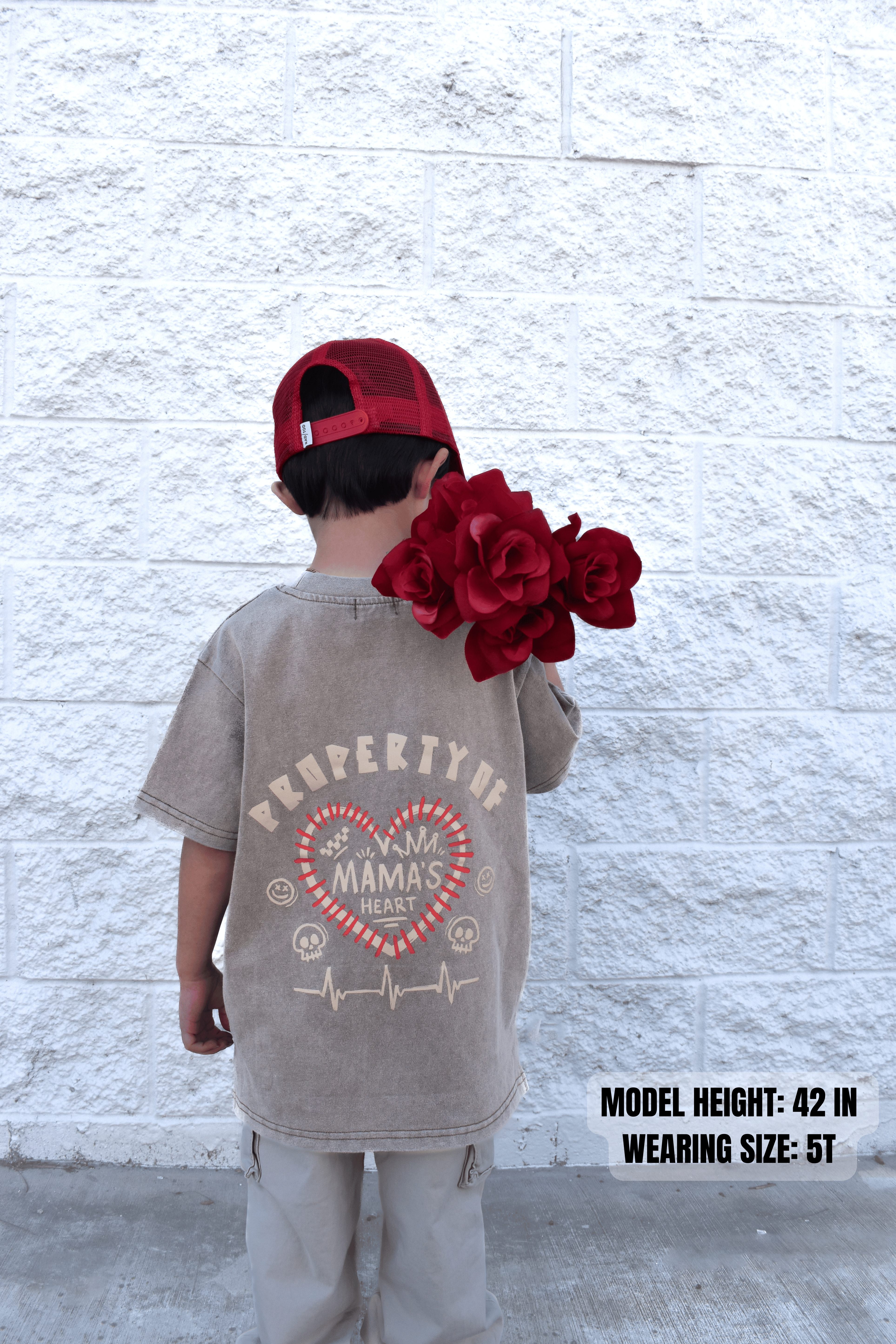 Kid wearing Property of Mama’s Heart acid wash beige t-shirt with flowers in hand