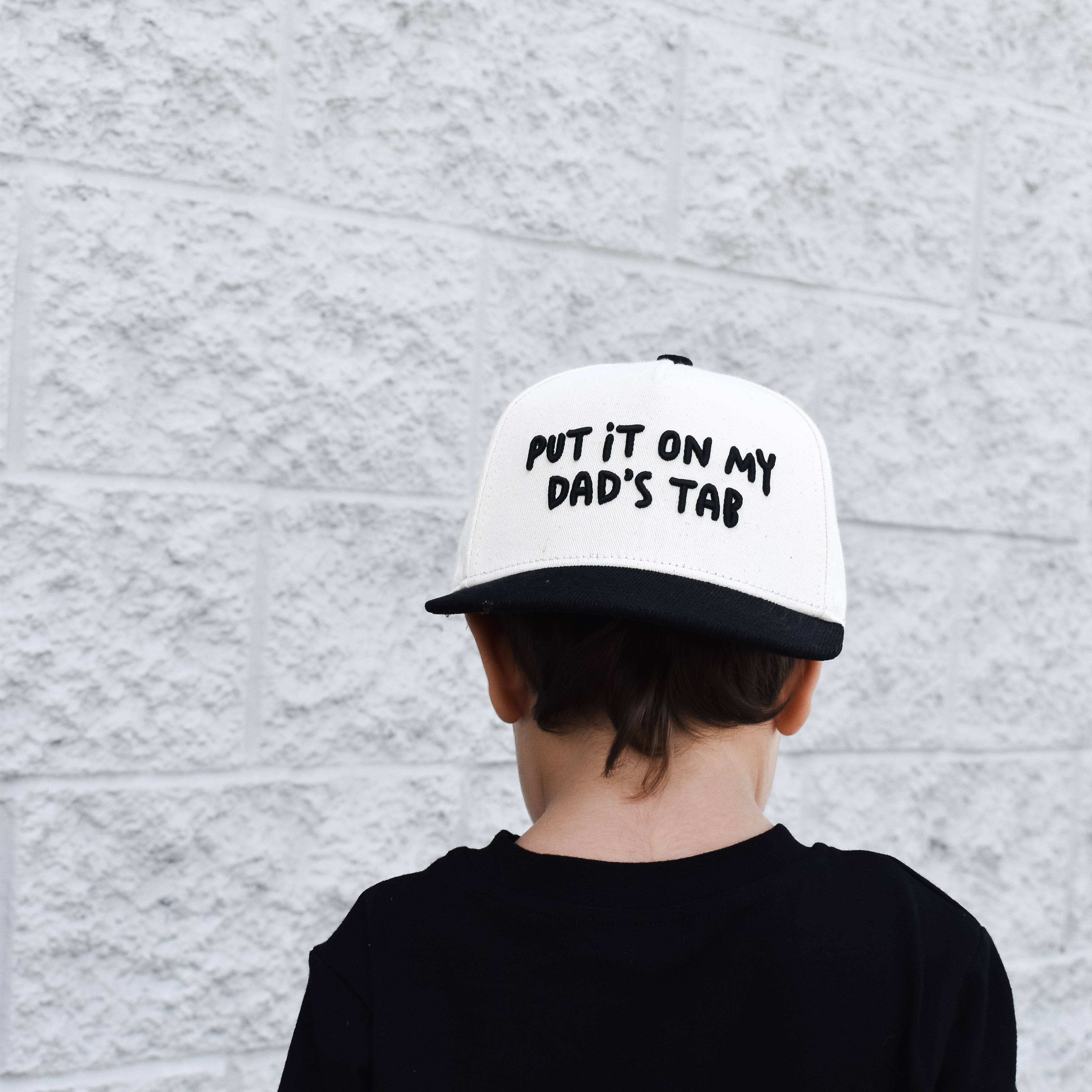 hild wearing Put It On My Dad’s Tab snapback outdoors while playing