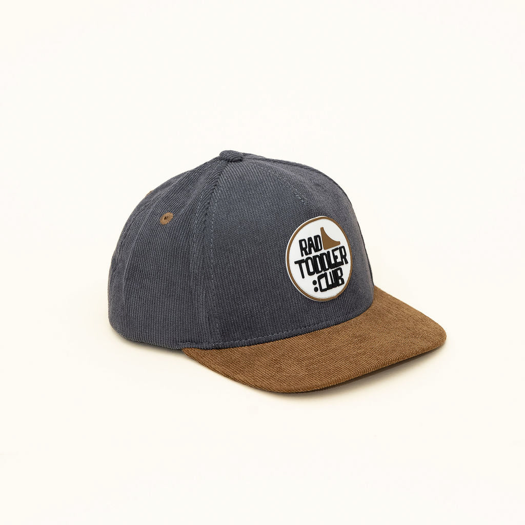 Side view of gray and brown RAD TODDLER Skate Club snapback showing embroidered patch detail.