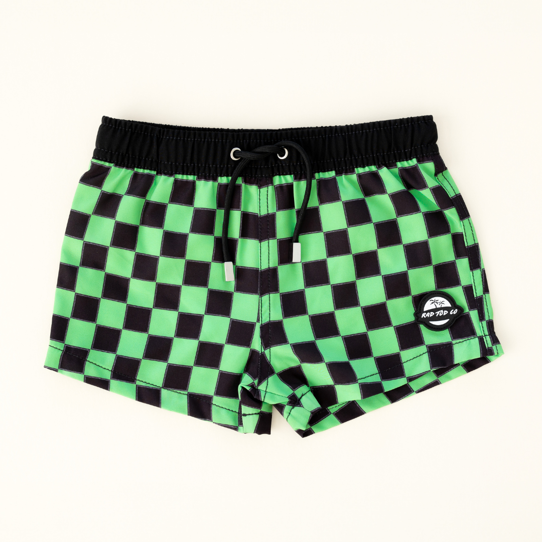 Bright checkered swim shorts with an elastic waistband and drawstring, made from quick-drying fabric. Ideal for swimming, beach trips, and outdoor activities. Features vibrant patterns and a comfortable fit for active kids.